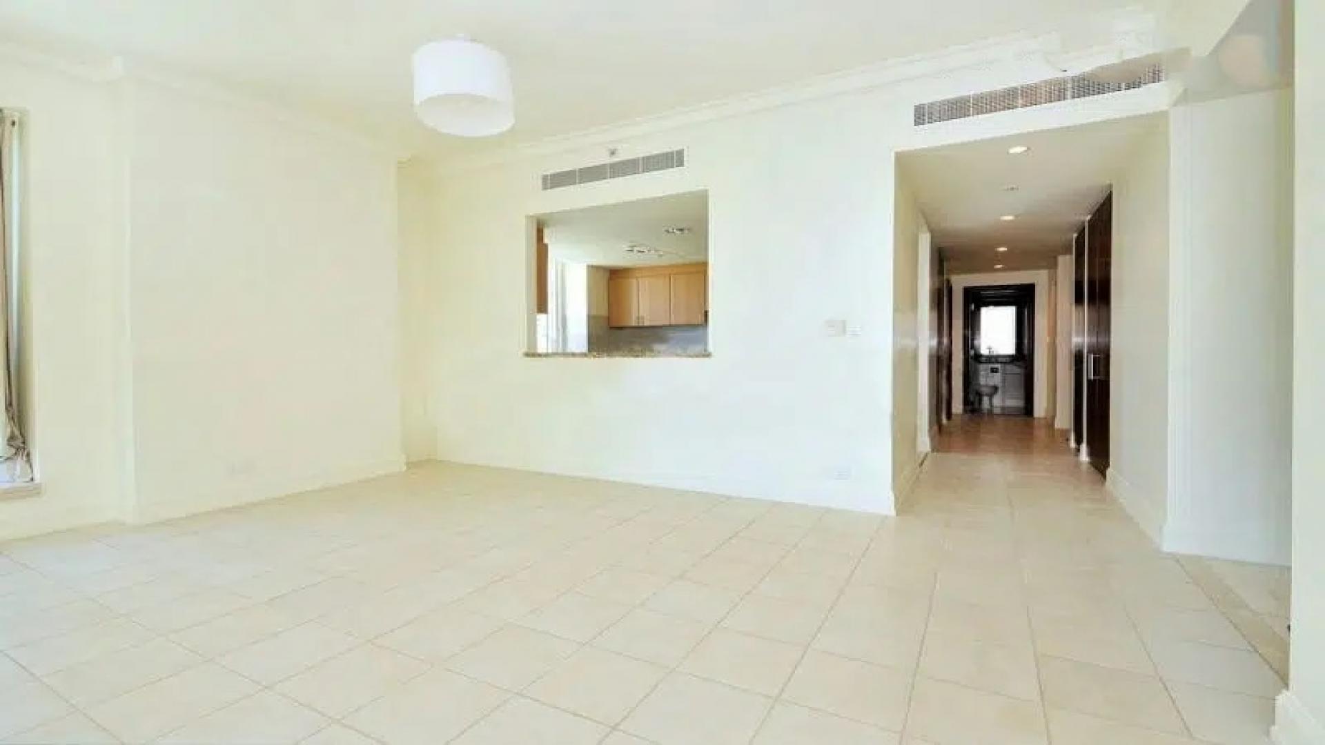 Empty living room in 2-bedroom apartment, Dubai Marina, with large windows and tiled floor
