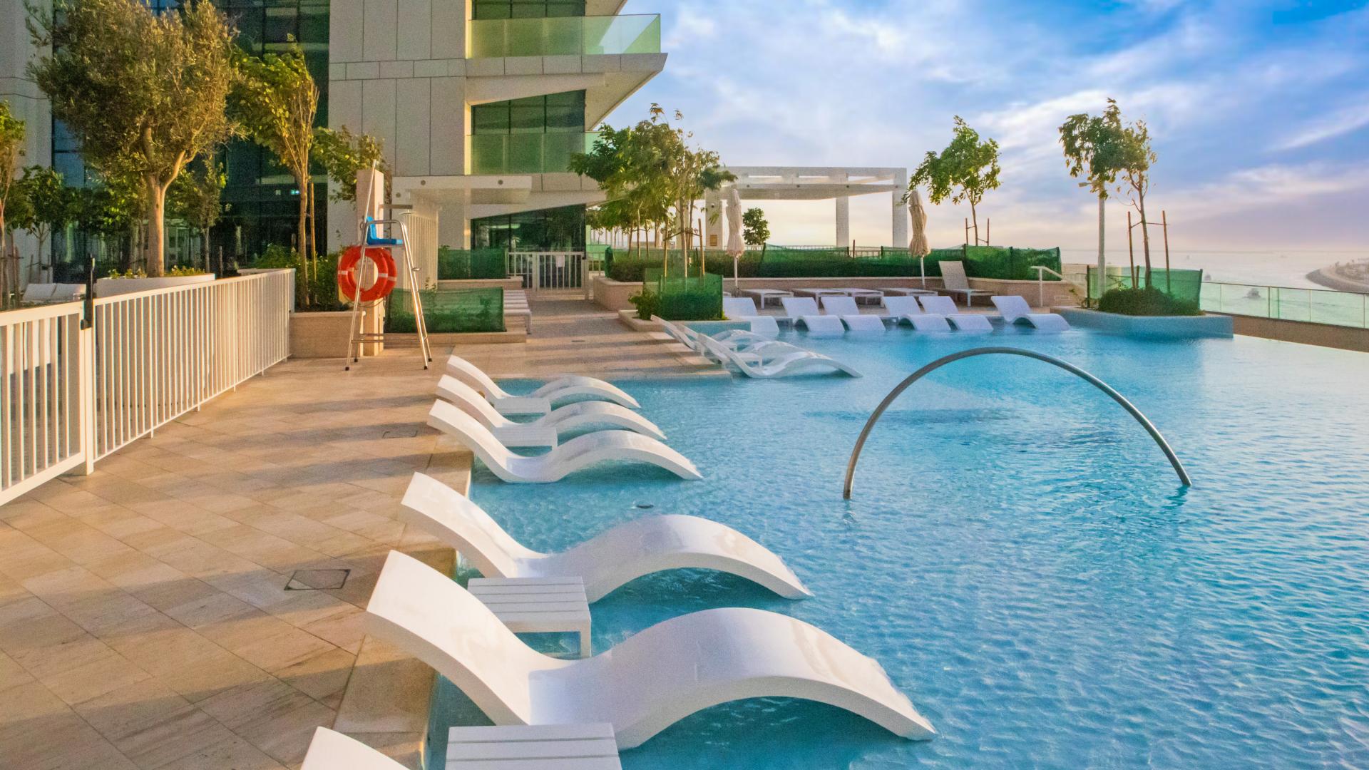 Empty bedroom with white walls and built-in wardrobe in Beach Vista apartment, Emaar Beachfront