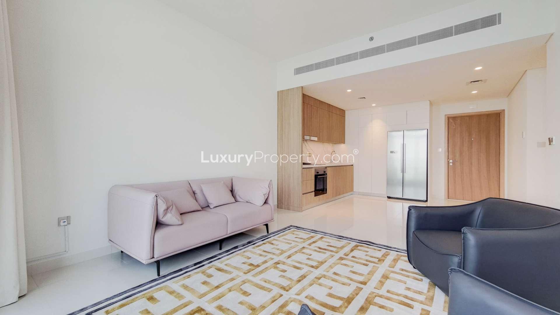 Contemporary living room in Dubai Harbour apartment with modern furnishings and sleek kitchen design