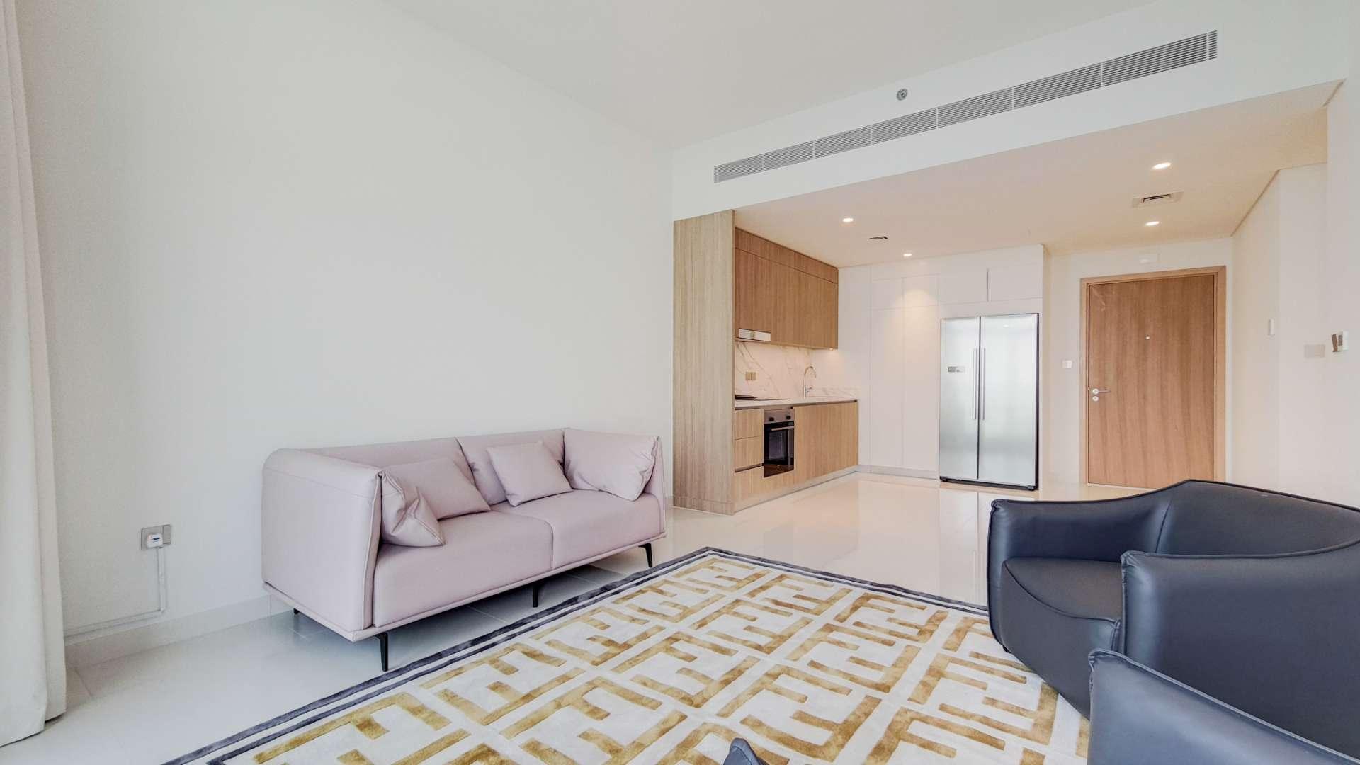 Contemporary living room in Dubai Harbour apartment with modern furnishings and sleek kitchen design