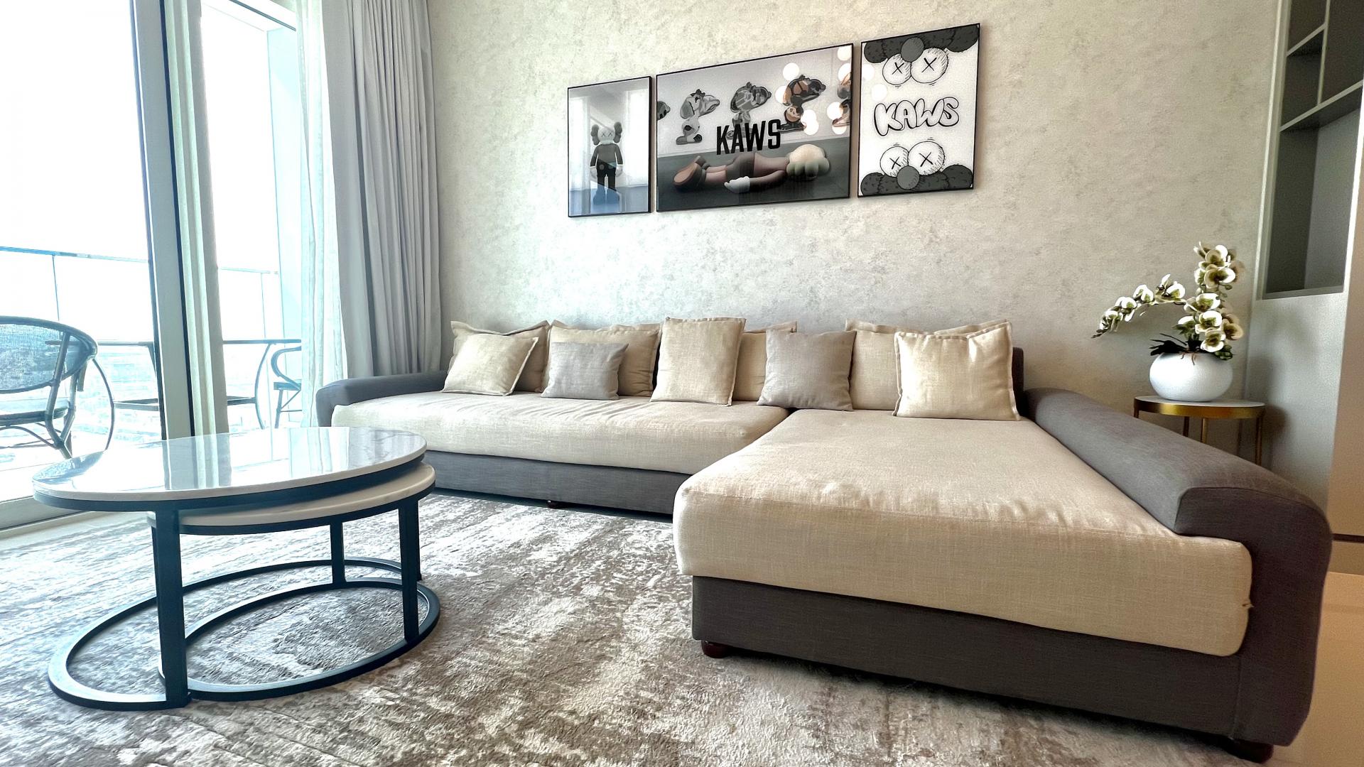 "Stunning Palm view from balcony of Emaar Beachfront apartment, Dubai Harbour, for rent.",Modern living room in Emaar Beachfront apartment, featuring stylish decor and large windows