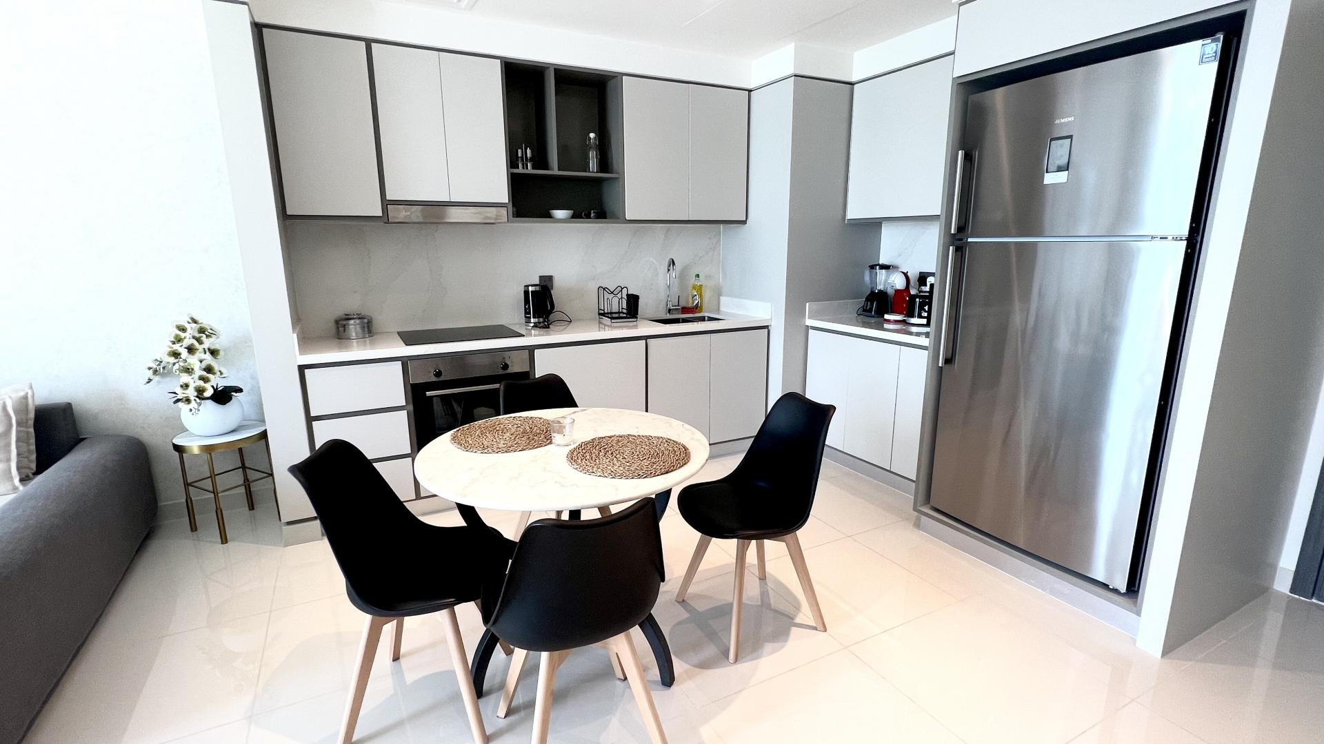 Modern kitchen in Emaar Beachfront apartment, Dubai Harbour, with sleek design and dining area