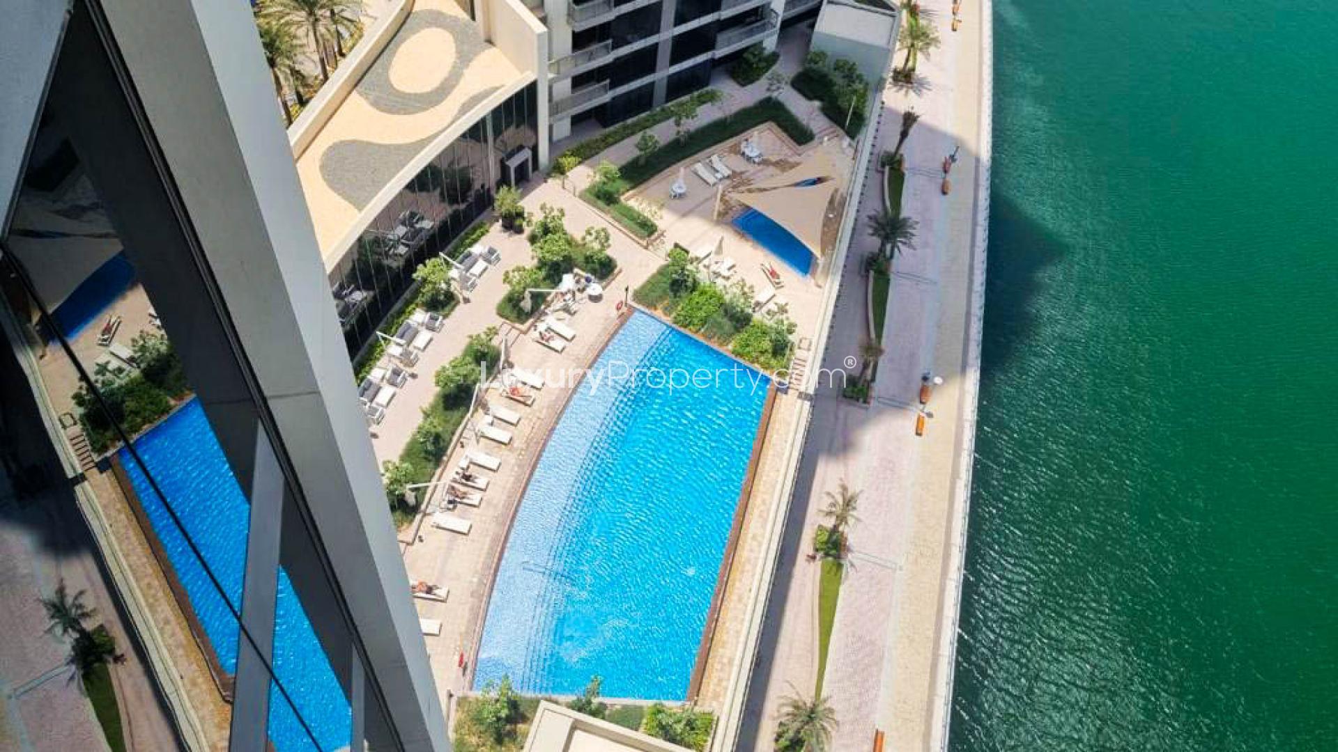 Aerial view of pool and waterfront at Dubai Marina 5242 apartment complex