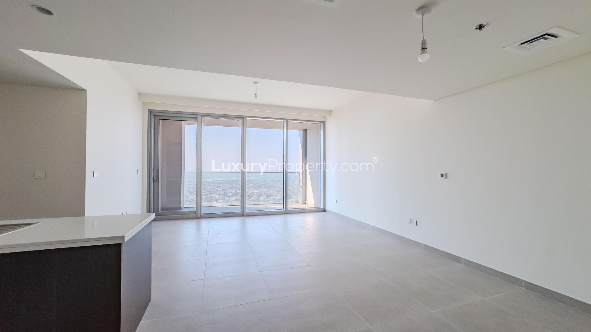Empty high-rise apartment living room with floor-to-ceiling windows and sea view in Downtown Dubai