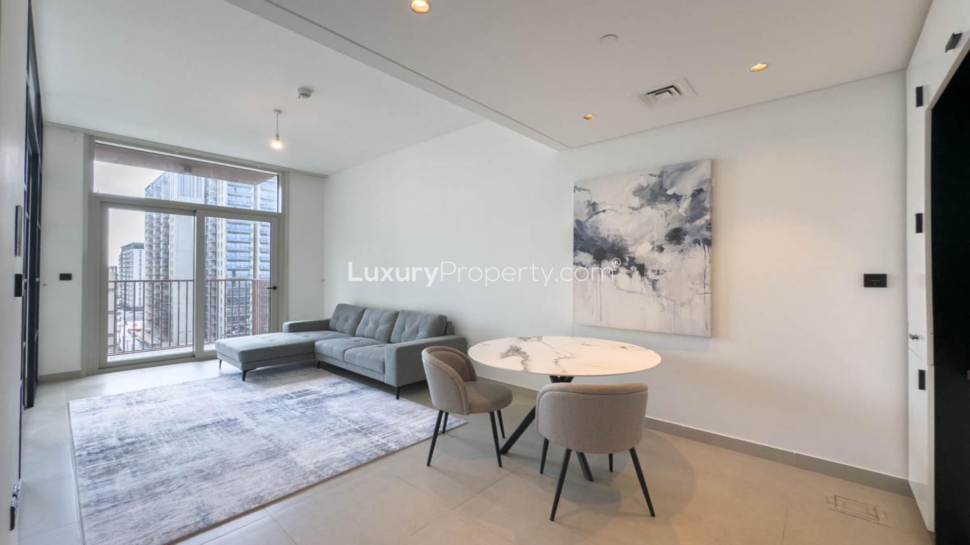 Modern living room in Dubai Hills Estate apartment, featuring large windows and sleek design