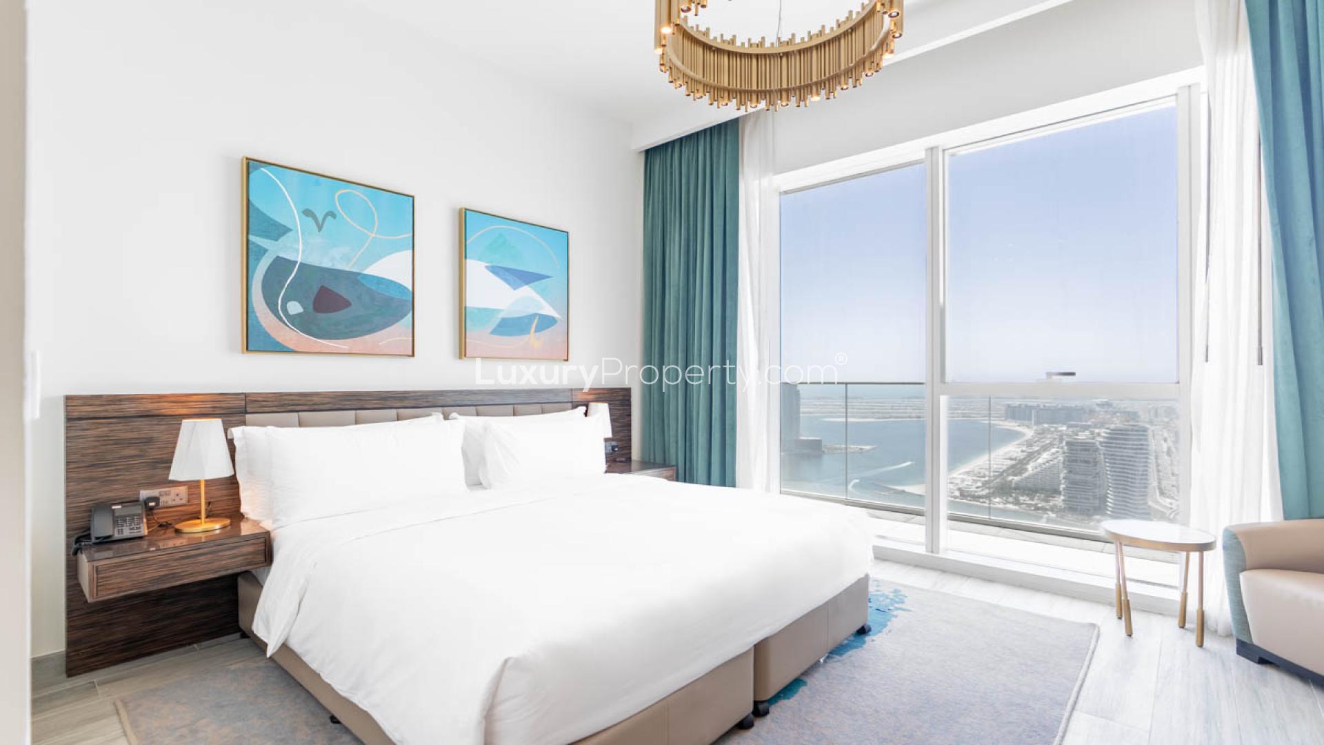 Modern Dubai Media City apartment living room with ocean view, blue sofas, and chic decor