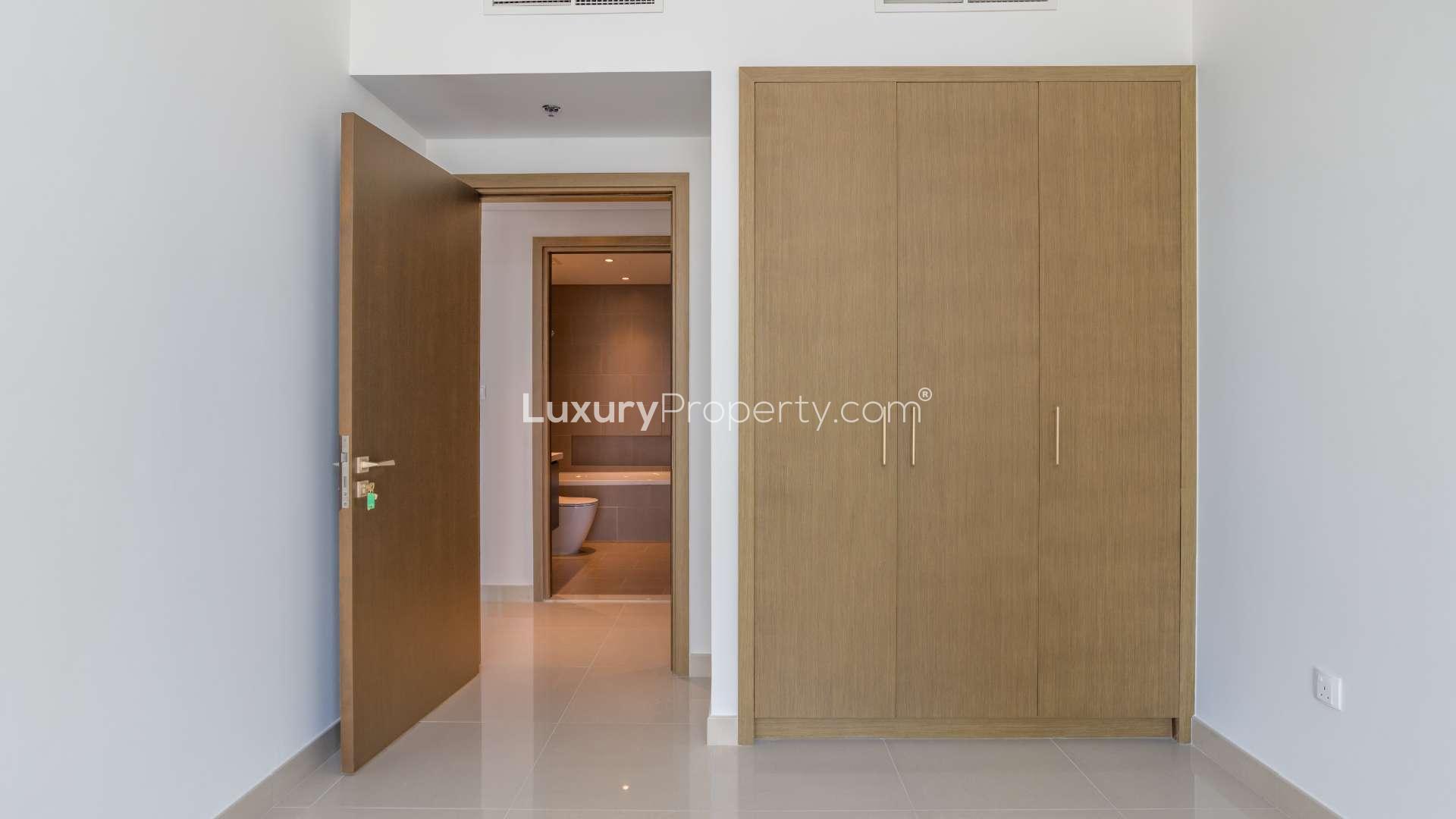Empty bedroom with built-in wardrobe and bathroom view in Dubai Creek Harbour apartment