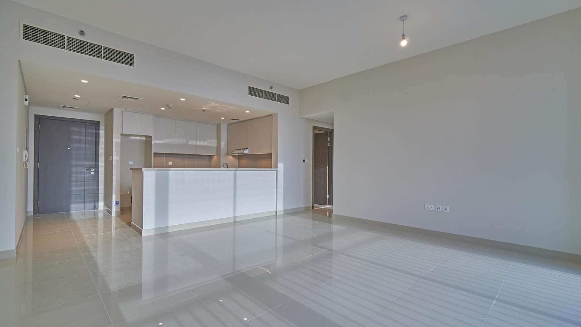Empty living room with large windows and balcony in Dubai Creek Harbour apartment