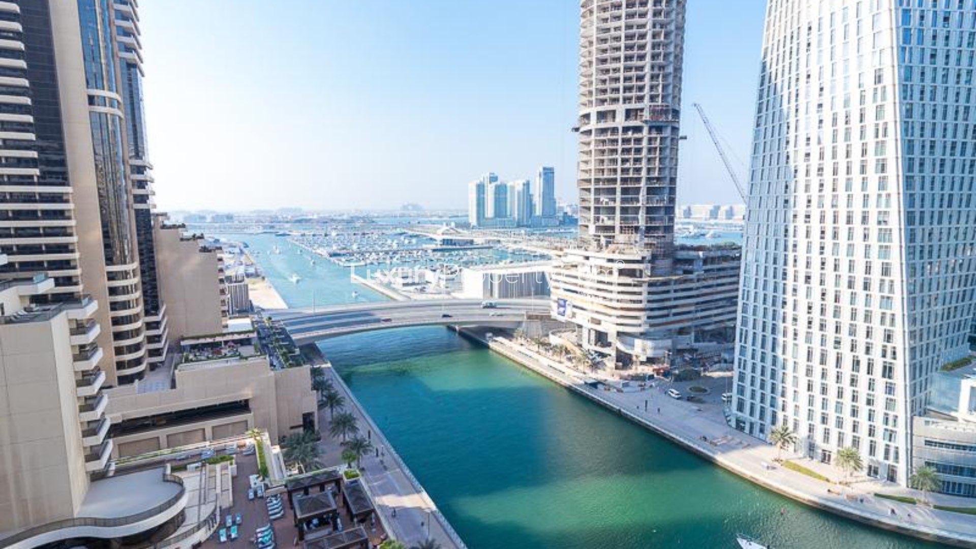 Furnished living room in Iris Blue apartment, Dubai Marina, with marina view through large windows