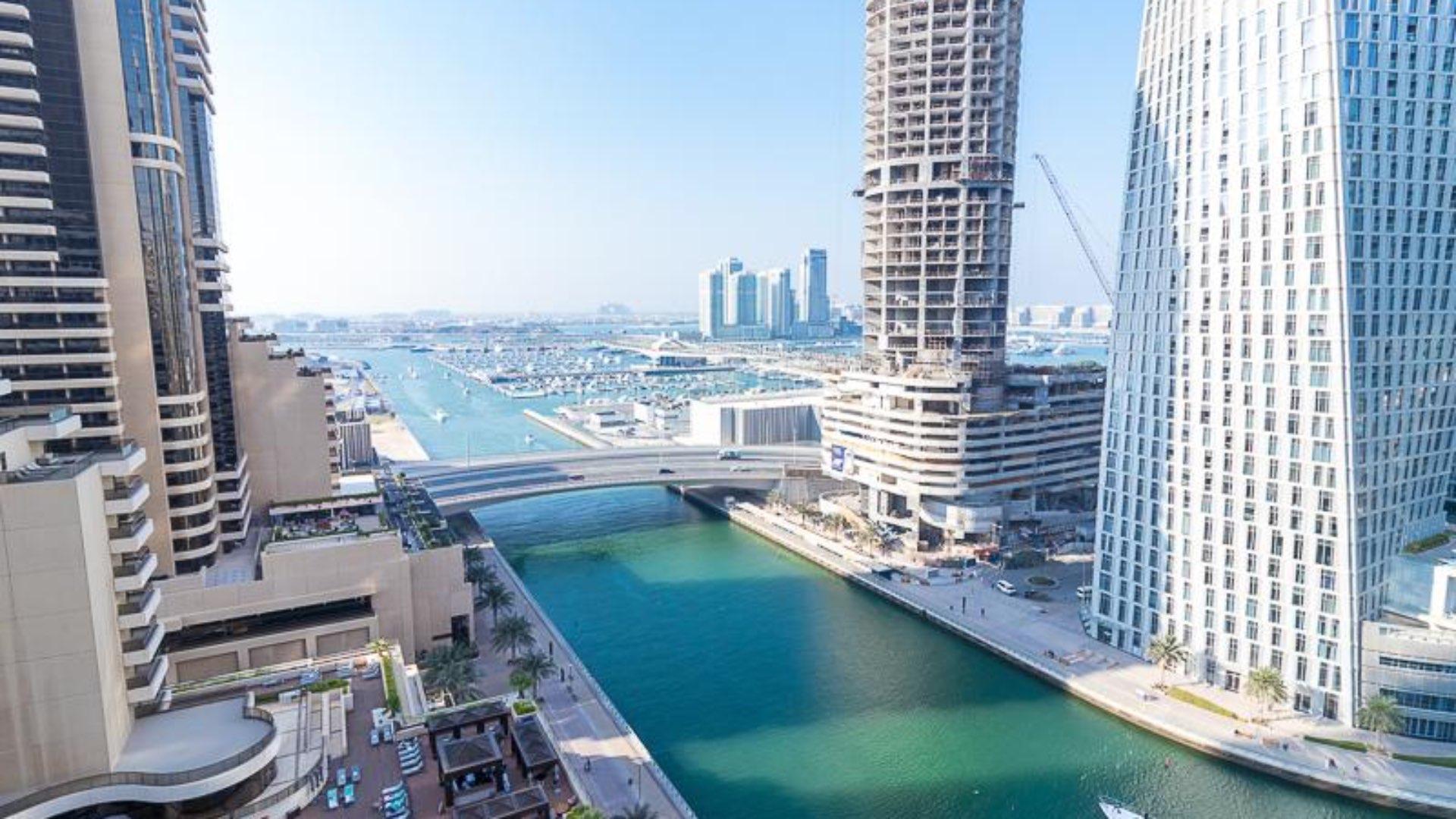 Furnished living room in Iris Blue apartment, Dubai Marina, with marina view through large windows