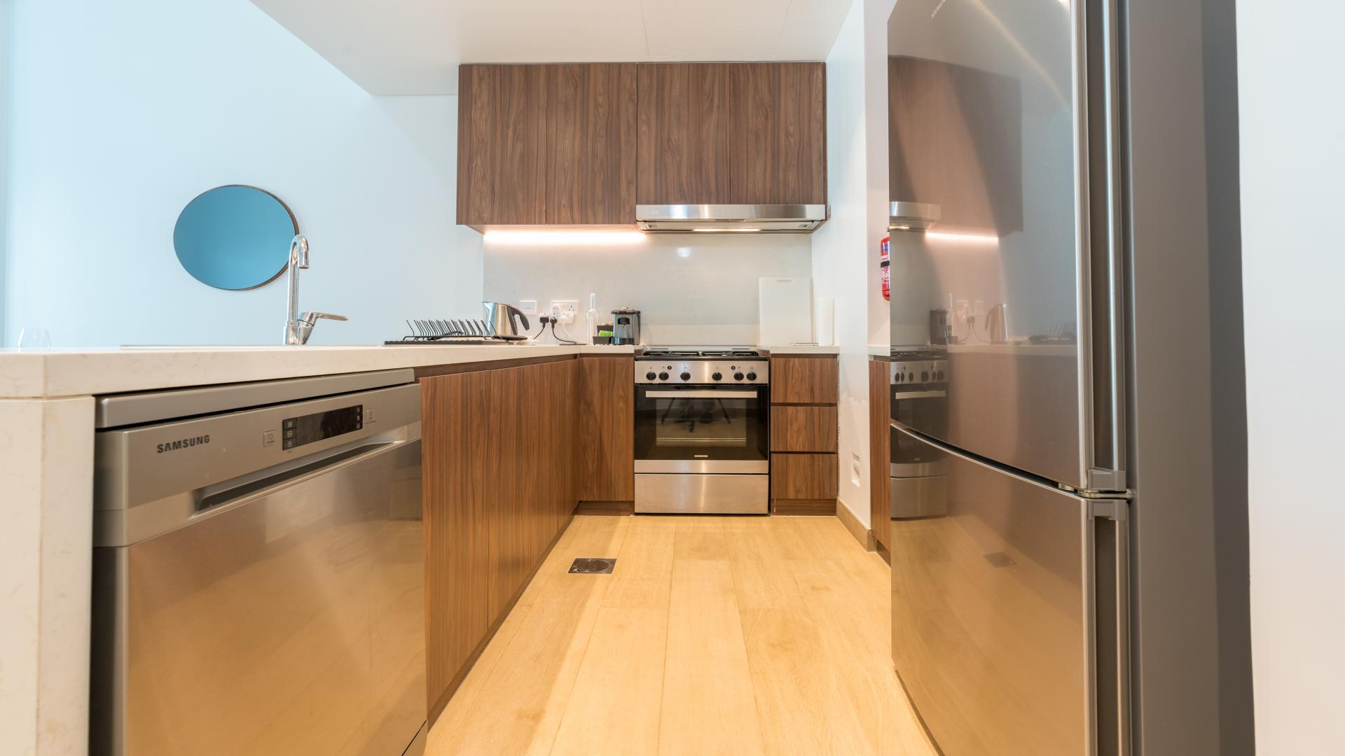 Modern kitchen in exclusive La Mer apartment, Jumeirah, featuring sleek design and spacious layout
