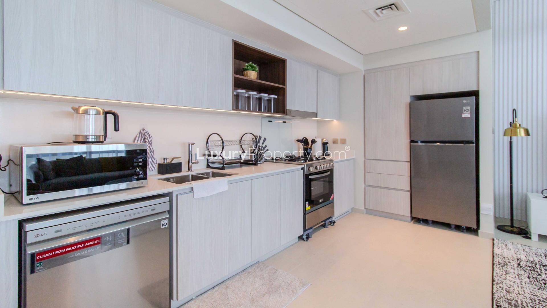 Modern living room in high-floor apartment, Dubai Creek Harbour, with stylish furnishings and open kitchen