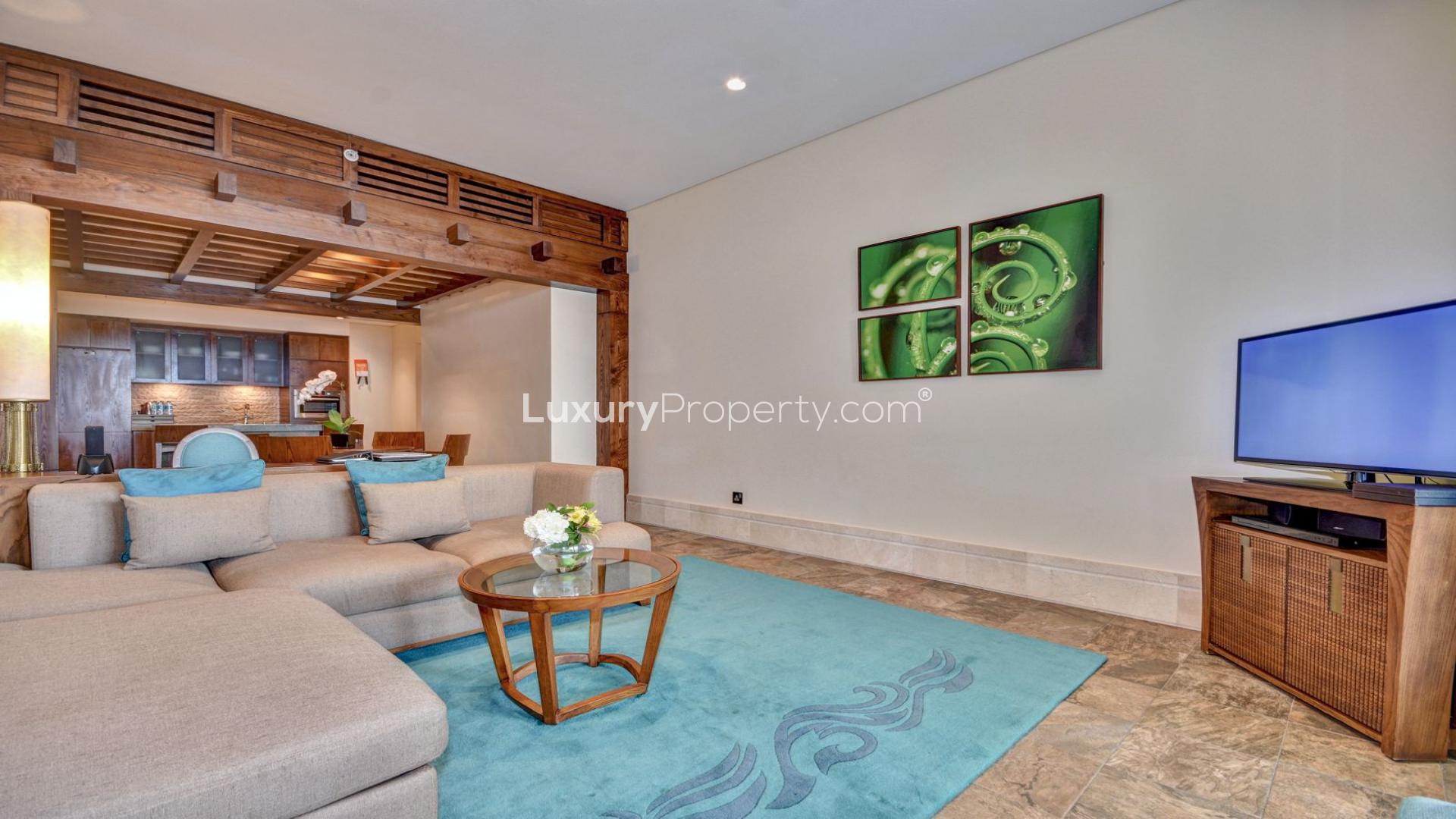 Elegant kitchen in Sofitel The Palm apartment, featuring wooden cabinetry and stone countertops