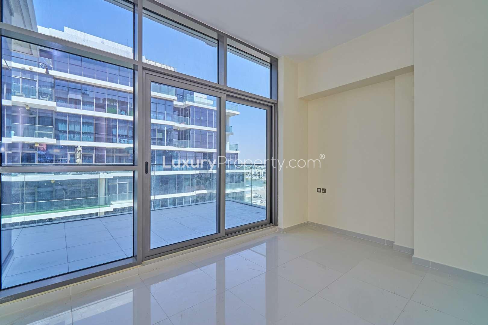 Bright living room with large windows in Golf Vista, DAMAC Hills apartment for rent