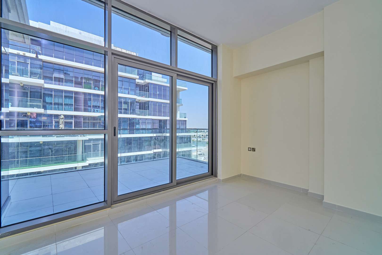 Bright living room with large windows in Golf Vista, DAMAC Hills apartment for rent