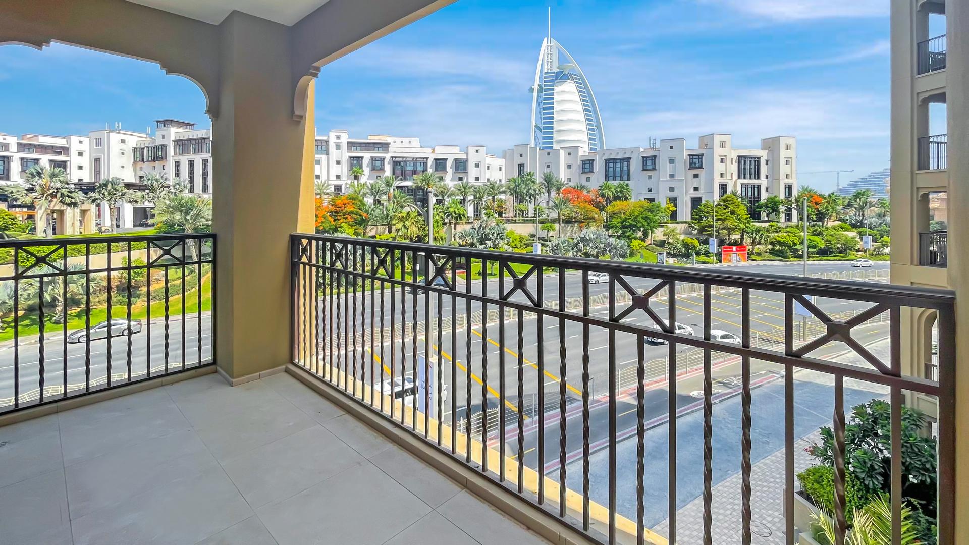 "Balcony view of iconic landmark from Madinat Jumeirah Living apartment in Umm Suqeim.","Spacious living room in Madinat Jumeirah apartment for rent, featuring large windows and tiled floor.",Bright living area in Madinat Jumeirah Living apartment, floor-to-ceiling windows, Umm Suqeim