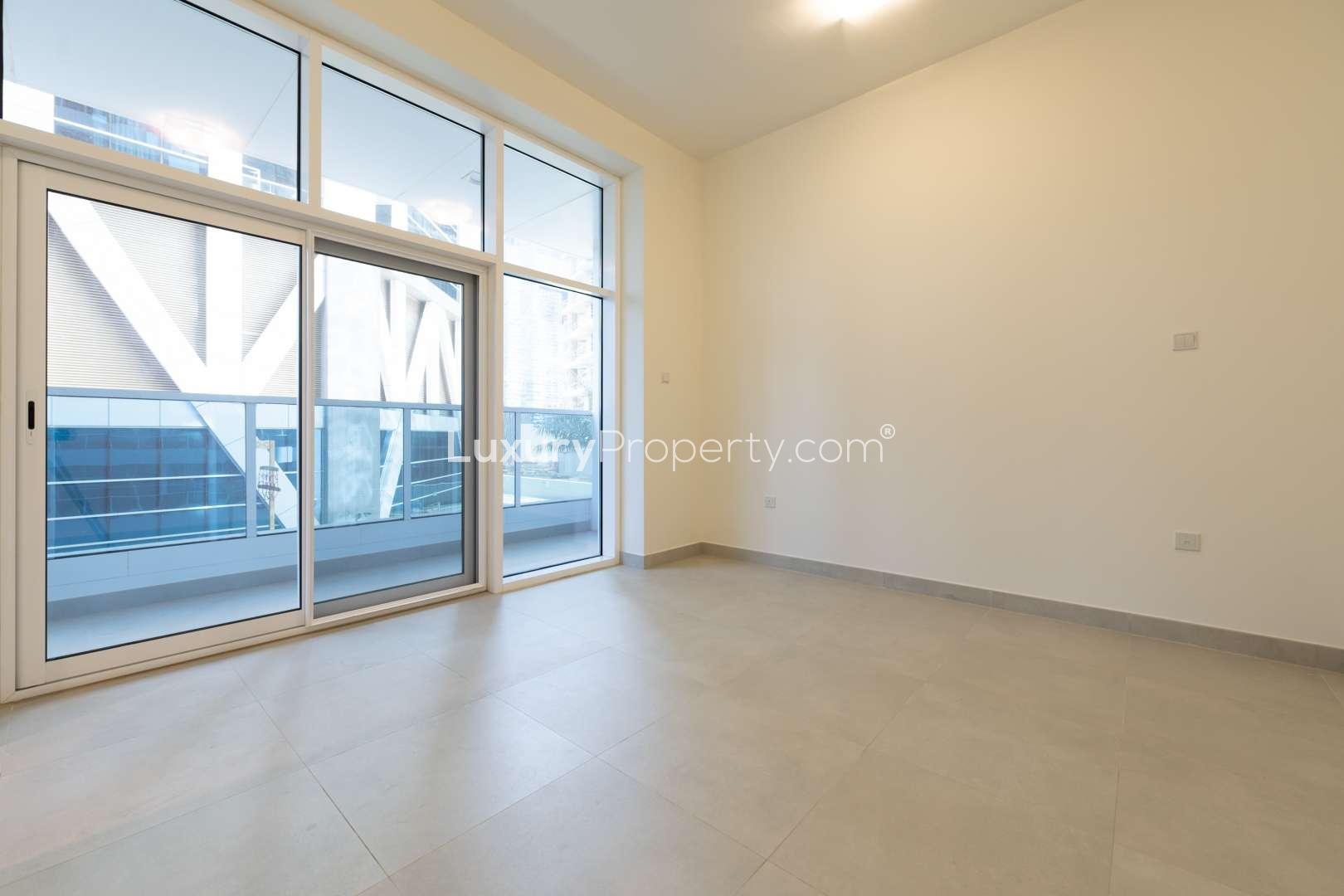 "Luxury lobby in Marina Arcade apartment, Dubai Marina, featuring modern decor and seating area.",Empty living room with large windows in modern Dubai Marina apartment for rent