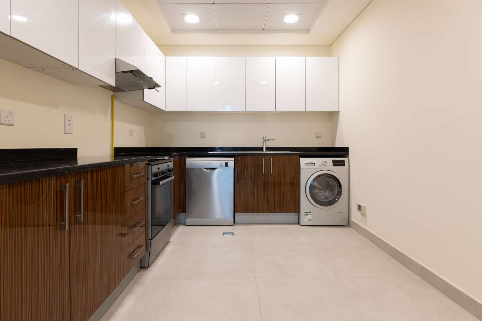 "Modern integrated kitchen in 2-bed apartment, Marina Arcade Tower, Dubai Marina, for rent.",Sunlit bedroom with large window and built-in wardrobe in Dubai Marina apartment for rent