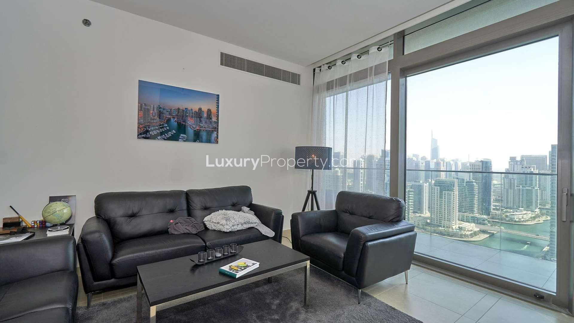 Living room in Marina Gate apartment with cityscape views, modern furnishings, and balcony access
