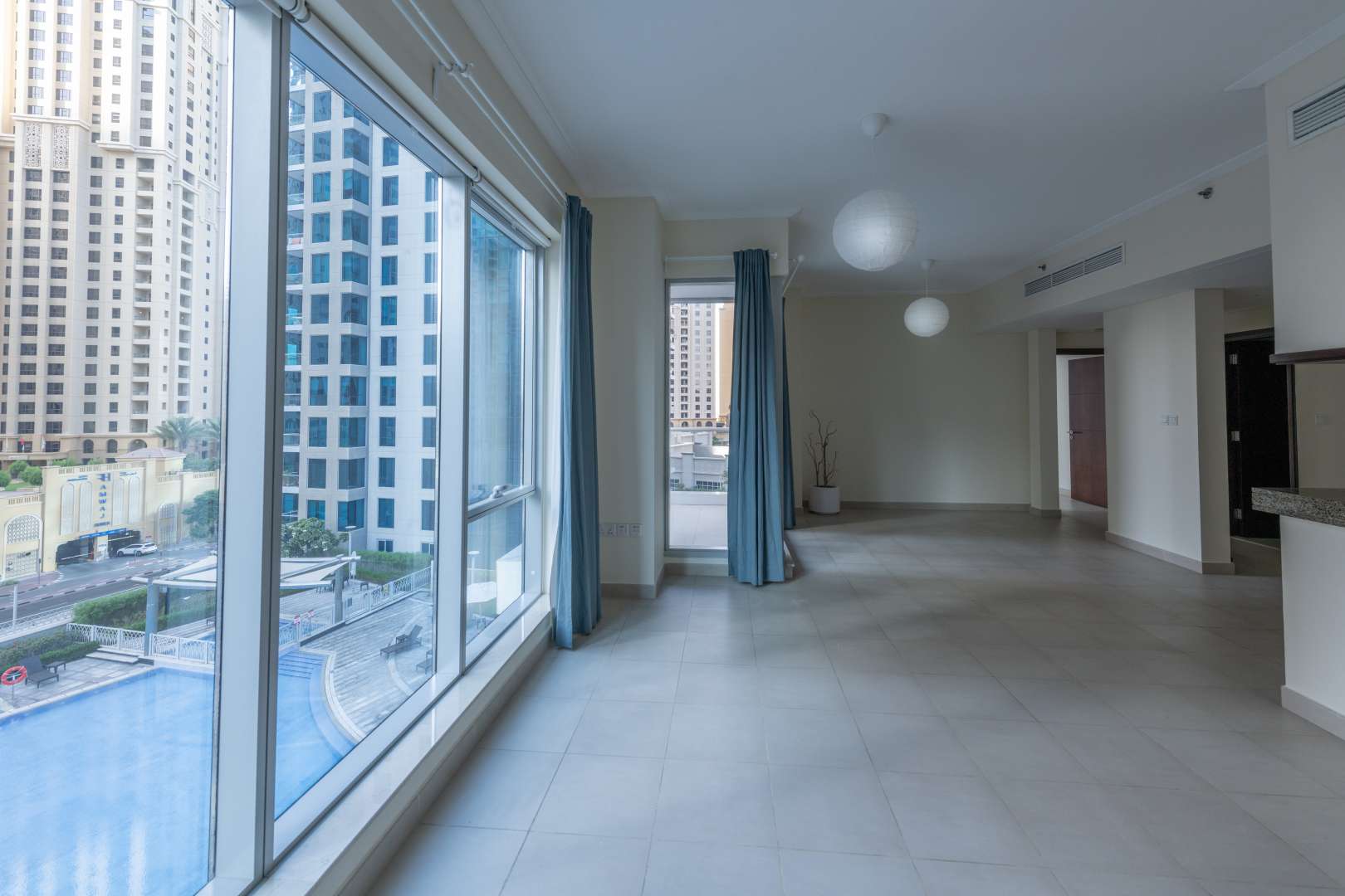 Bright living room in 2-bedroom Marina Promenade apartment with large windows and city views