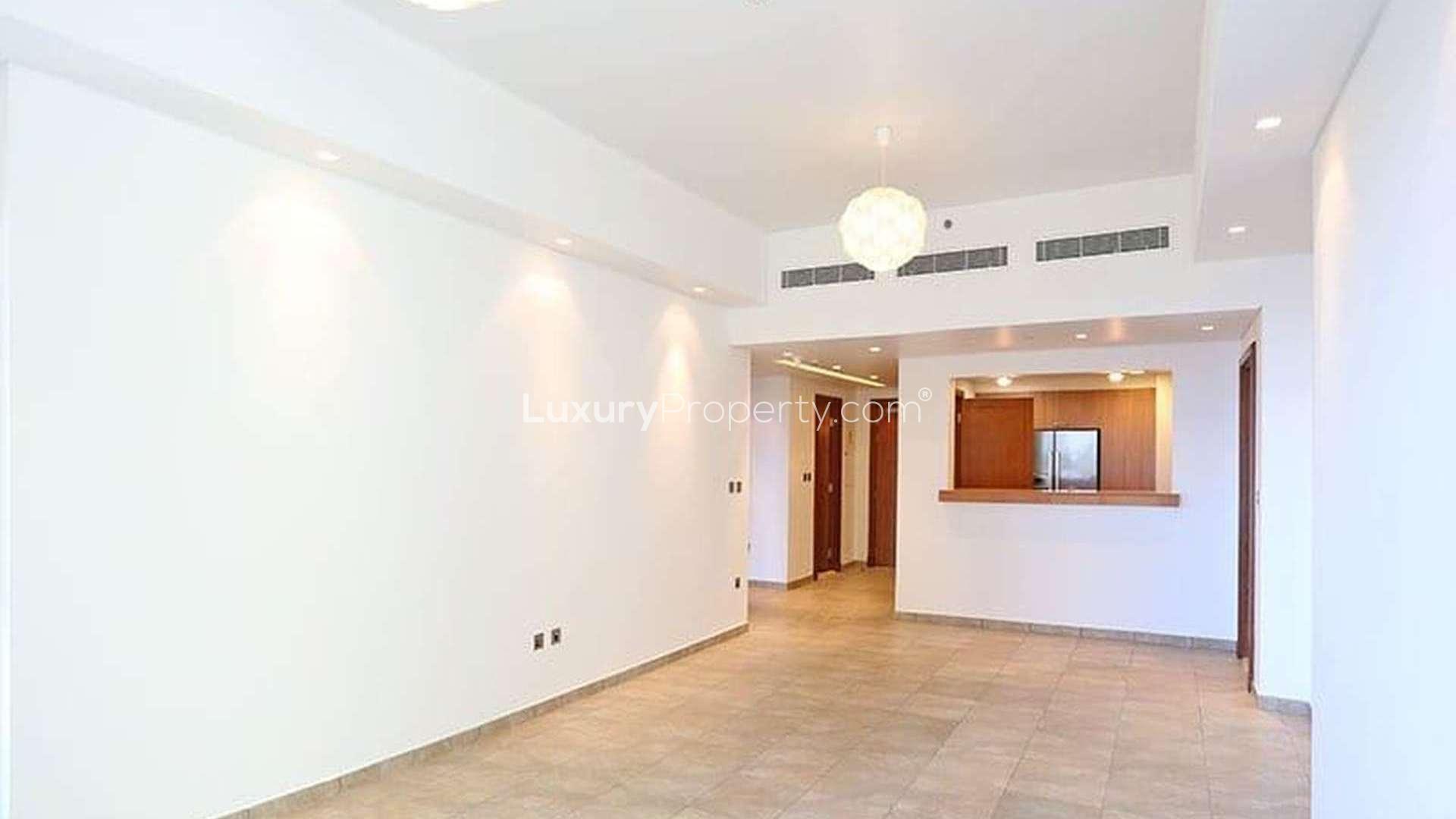 "Spacious living area in Palm Jumeirah apartment, open kitchen, modern design, Marina Residences.",Empty living room with tiled floor in Palm Jumeirah apartment, Marina Residences