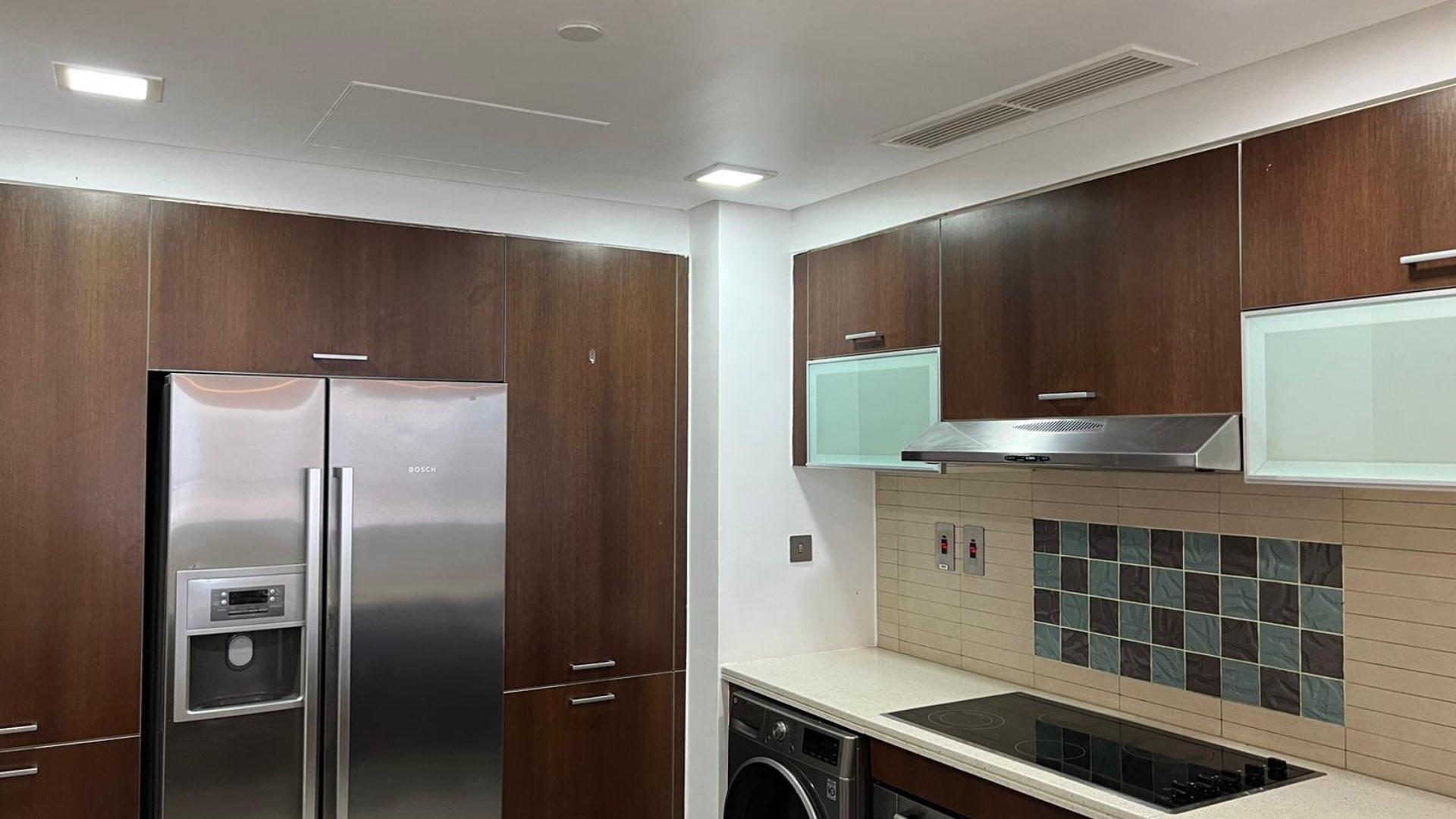 Modern kitchen in Marina Residences apartment, Palm Jumeirah, featuring sleek appliances and cabinetry