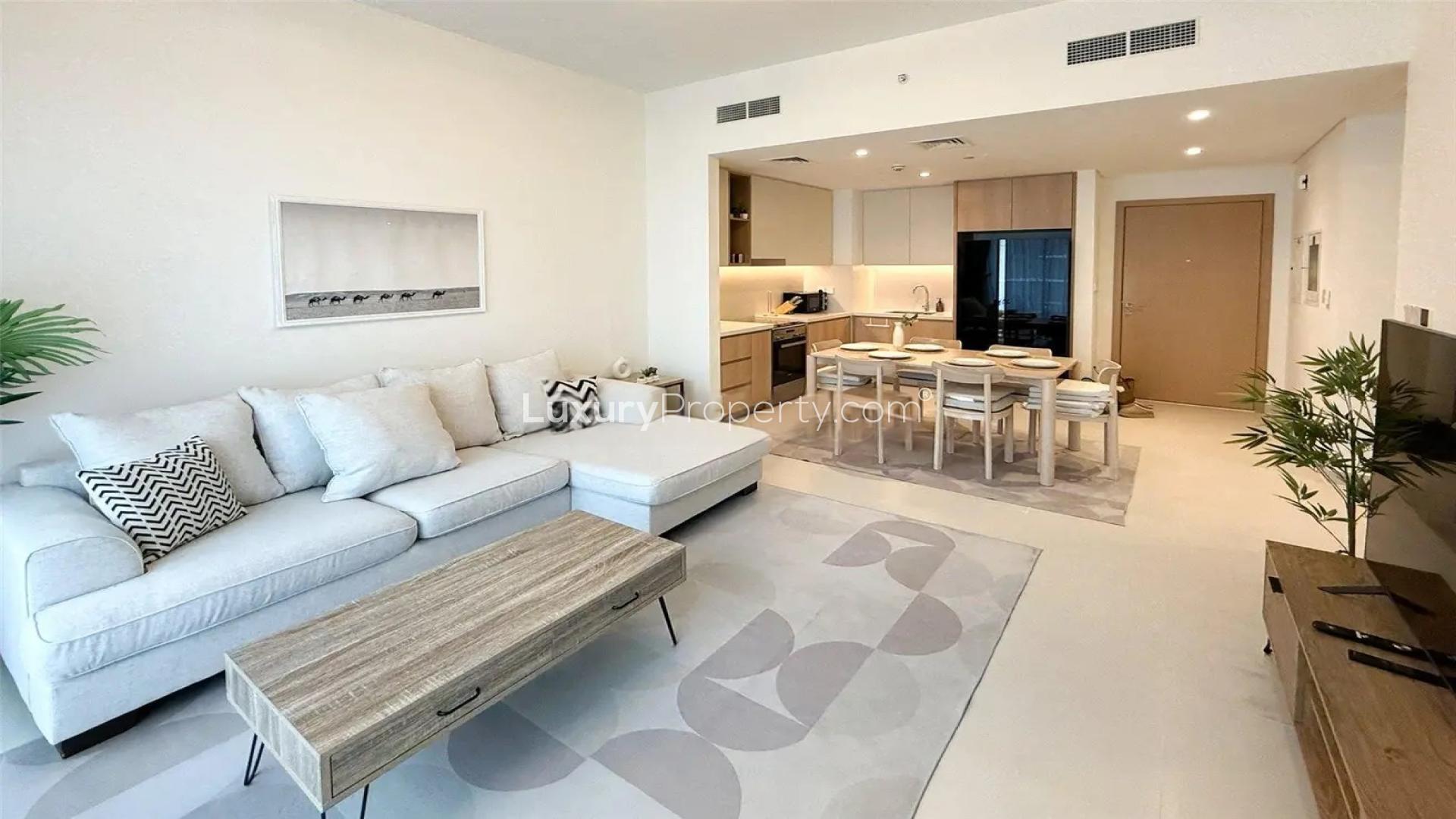 Modern living room in Dubai Creek Harbour apartment, featuring open kitchen and stylish furnishings