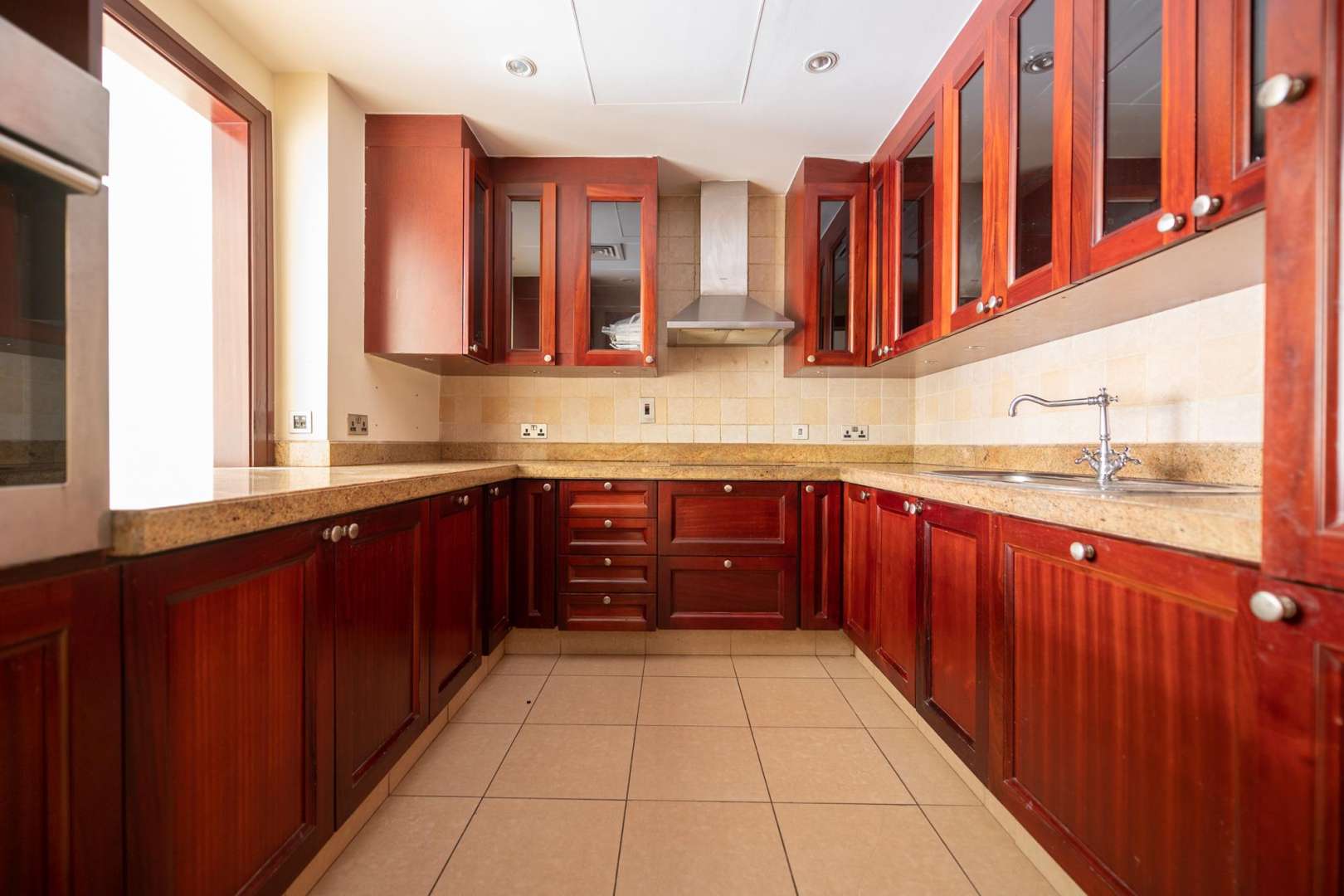 Empty living room in Miska apartment, Old Town, Dubai, with tiled floors and neutral walls