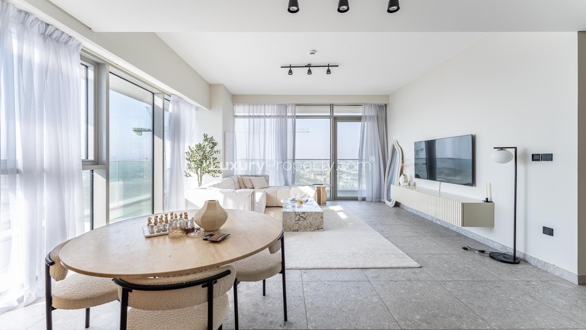 Modern living room in Golf Suites apartment, Dubai Hills Estate, with open kitchen and large windows