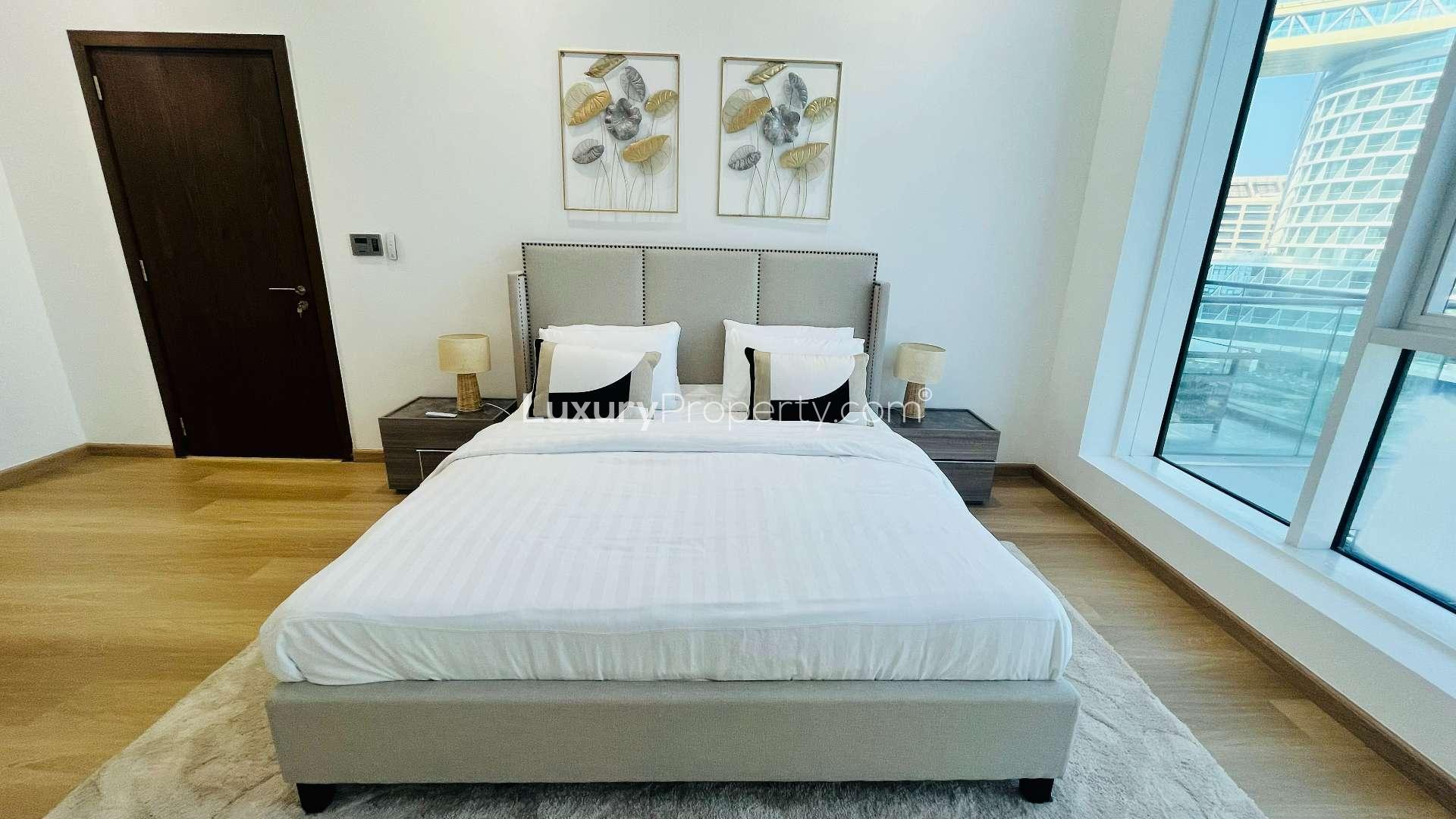 Refurbished Palm Jumeirah apartment living room with sea view, modern furnishings, and dining area