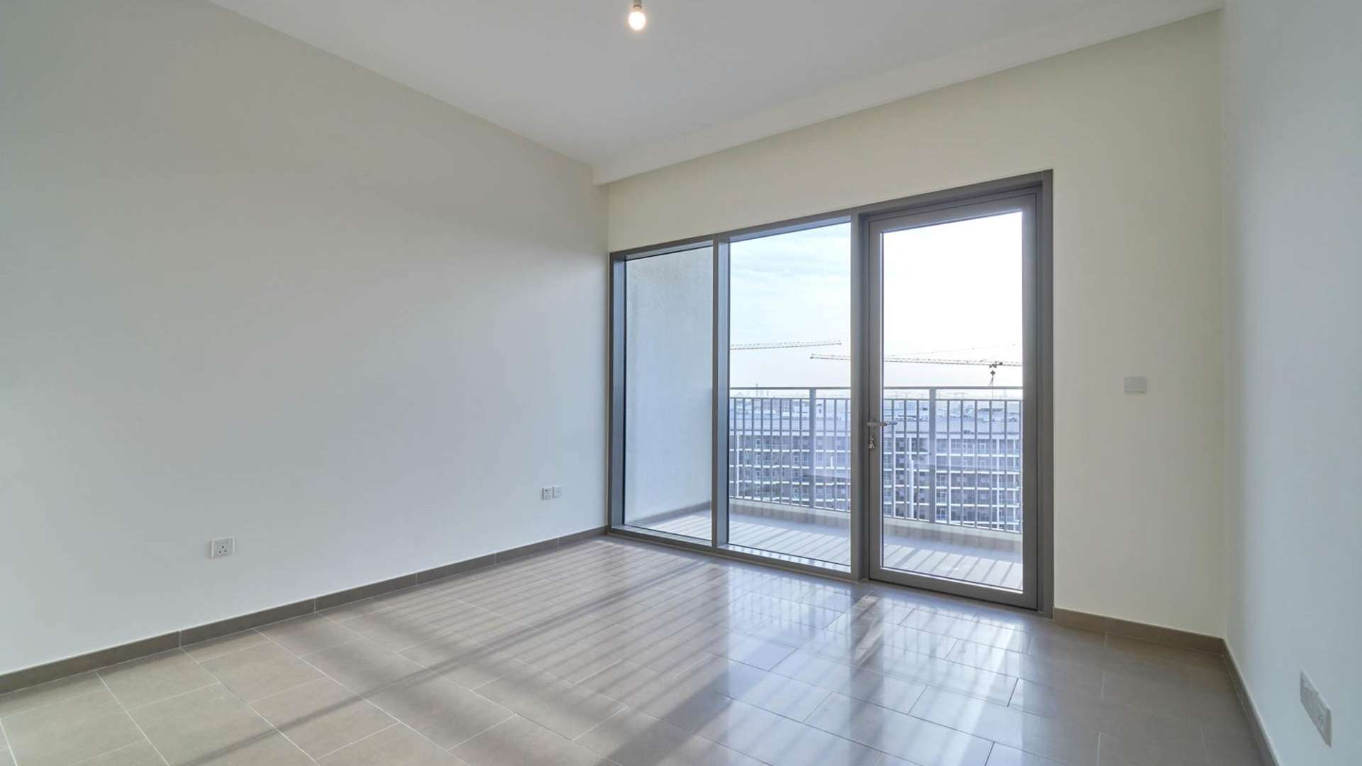 Empty bedroom interior in modern 2-bedroom apartment, Dubai Hills Estate, with bathroom entrance