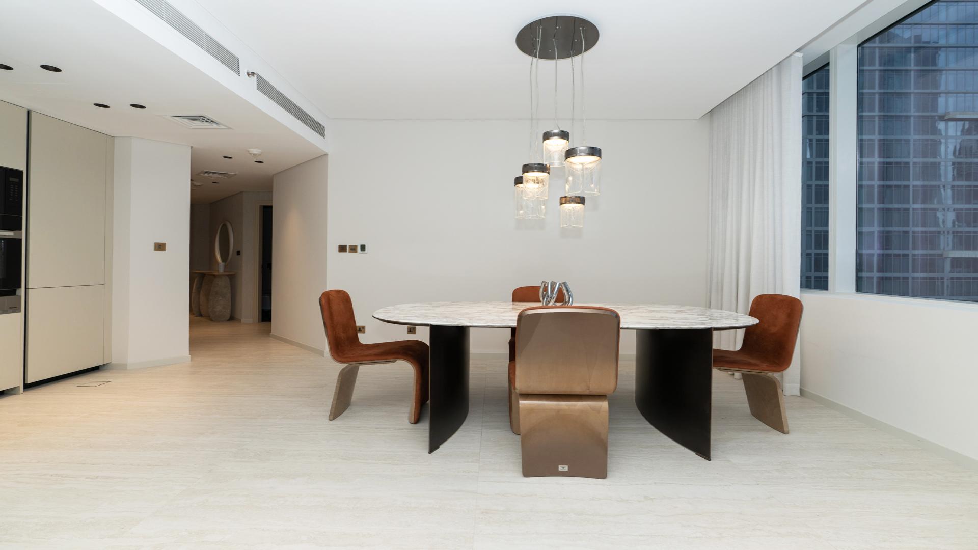 Modern dining area in Sky Gardens apartment, DIFC with city view windows and chic decor