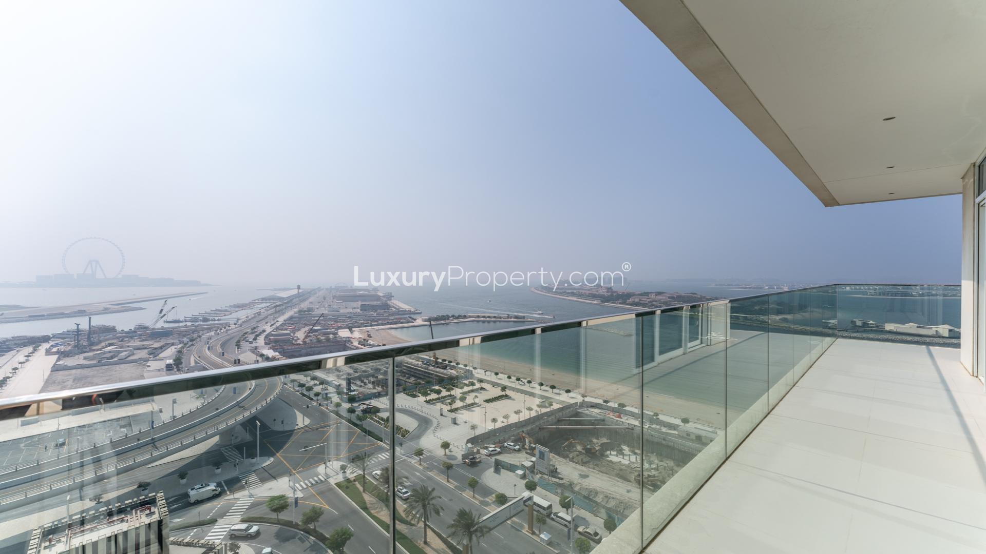 Bright living room with large windows offering stunning views of Palm and Marina, Emaar Beachfront