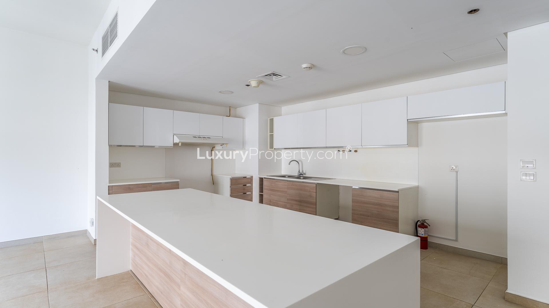 Modern kitchen and living area in Jumeirah Golf Estates apartment, Al Andalus community