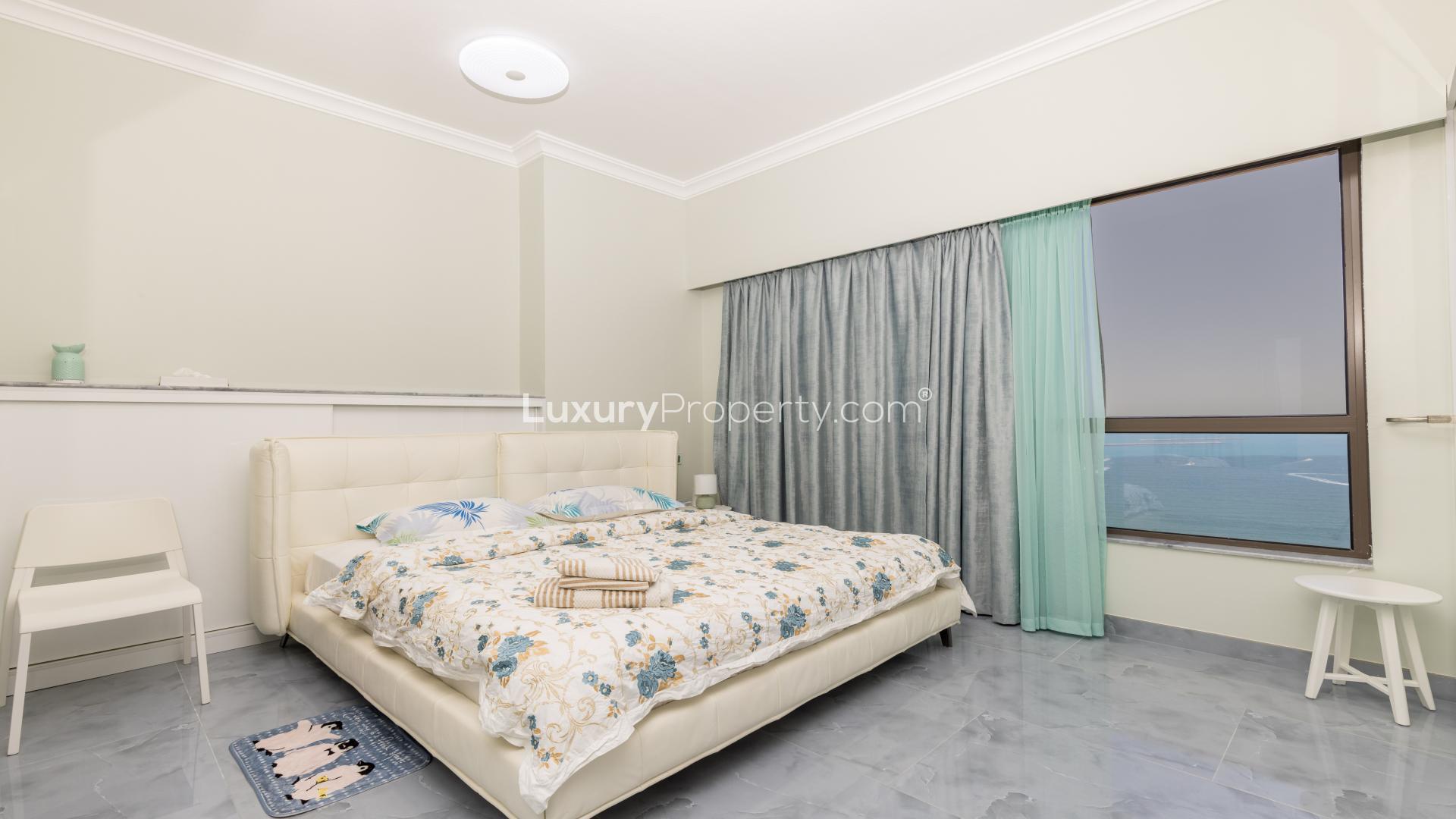 Spacious bedroom in JBR apartment with modern furnishings and large mirrored closet