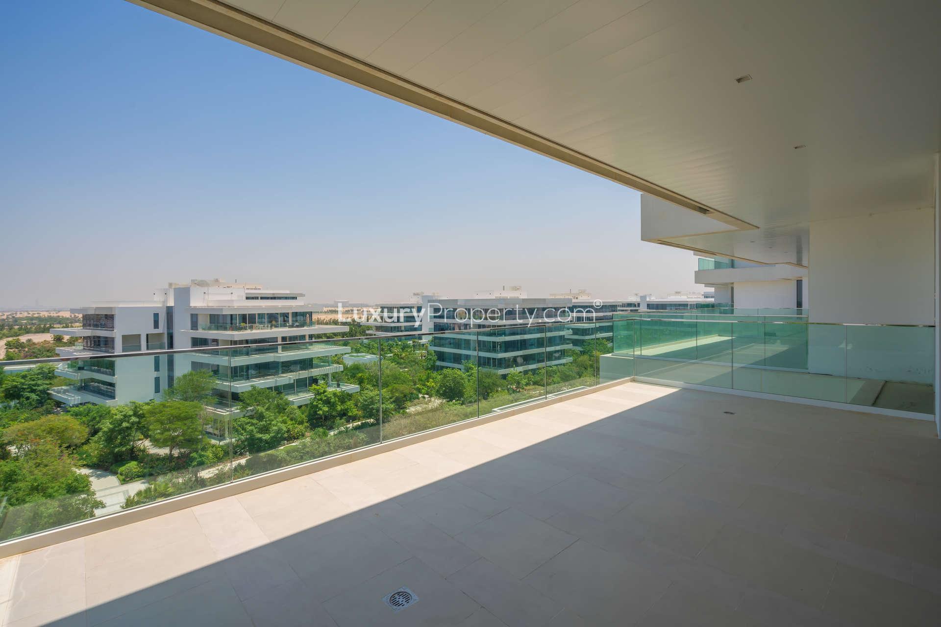 Spacious open-plan living area in Al Barari apartment with modern kitchen and large windows