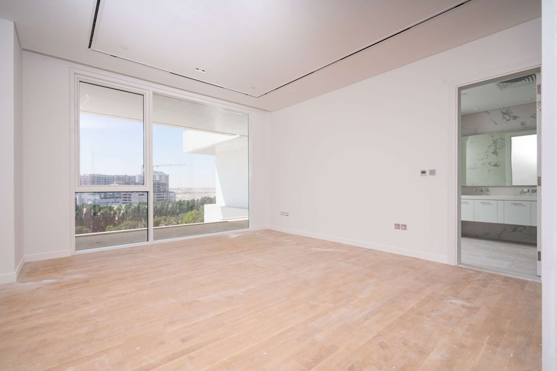 "Spacious balcony with scenic views in Seventh Heaven, Al Barari apartment for rent.",Modern living room with large window in Seventh Heaven apartment, Al Barari