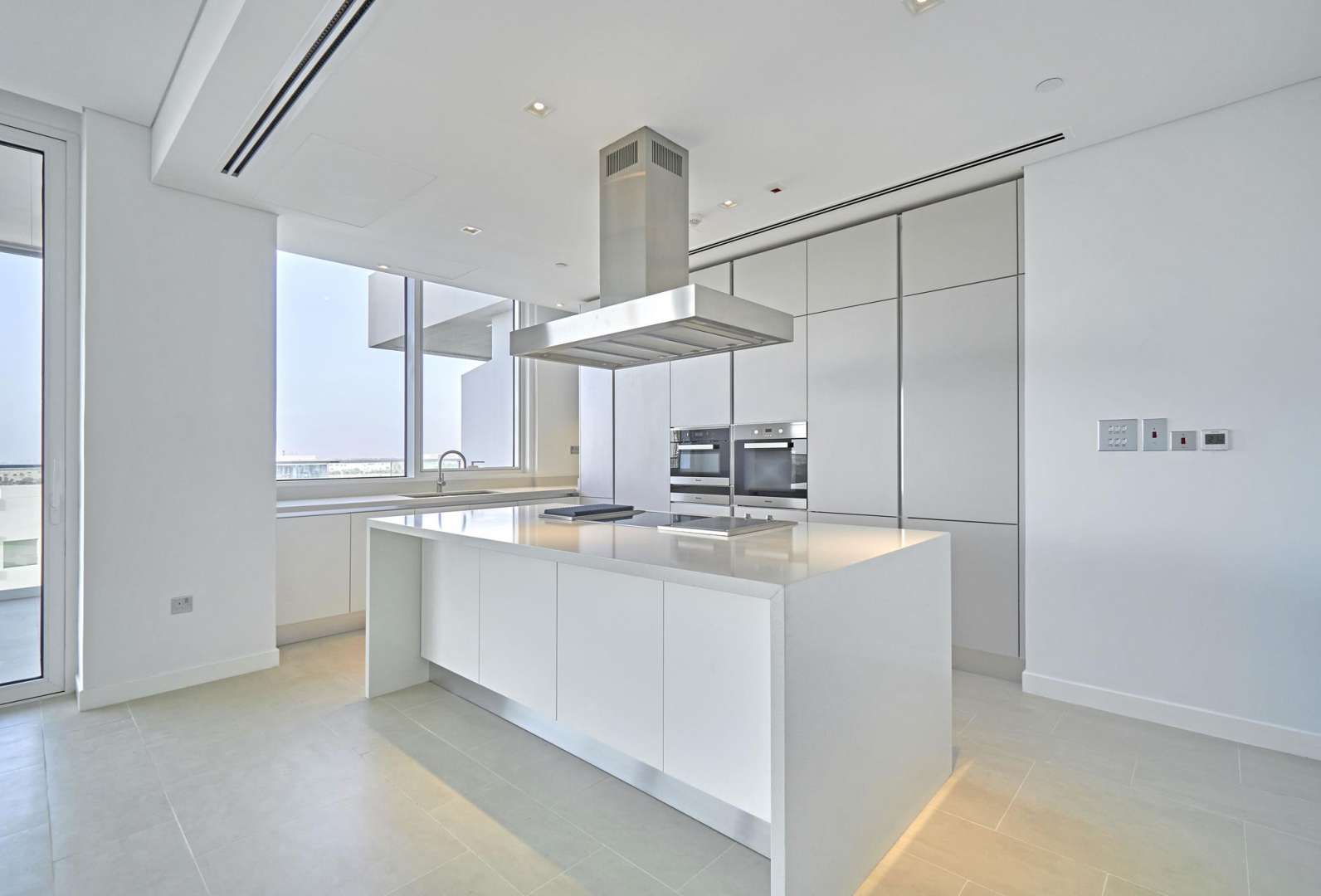 Open-plan living area in Seventh Heaven apartment, Al Barari, with large windows and modern kitchen