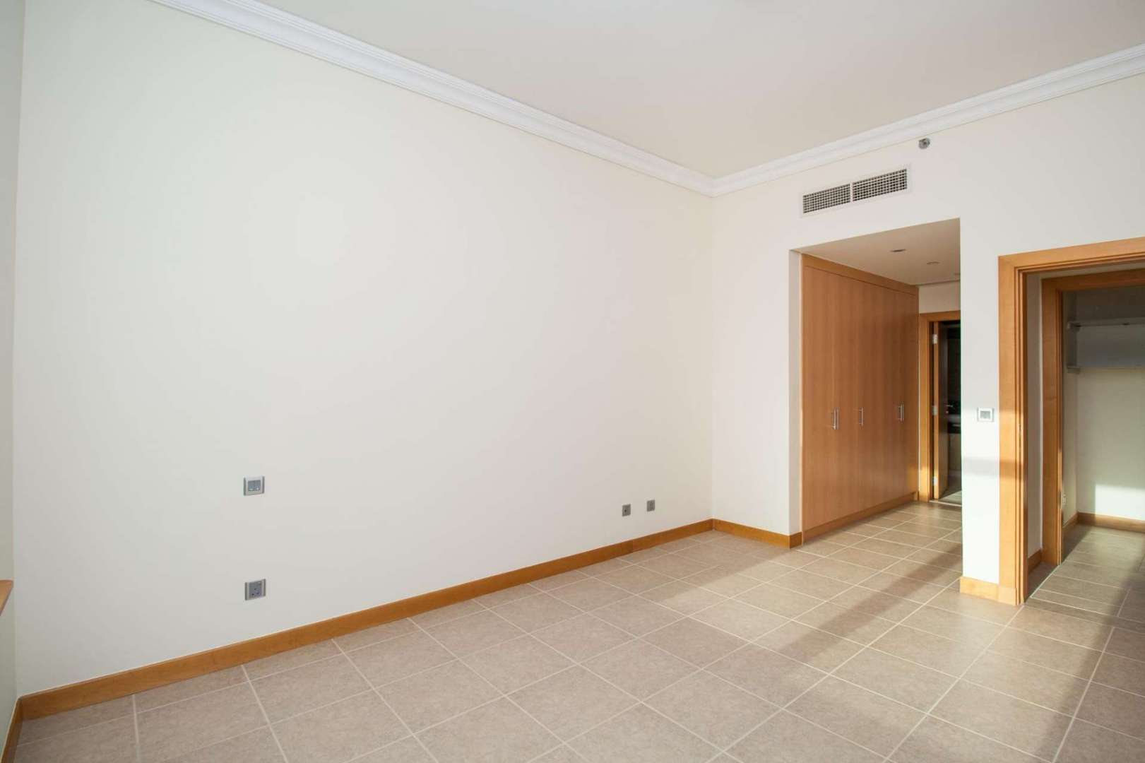 Bright living room in Shoreline Residences apartment, Palm Jumeirah, with tiled floor and archway
