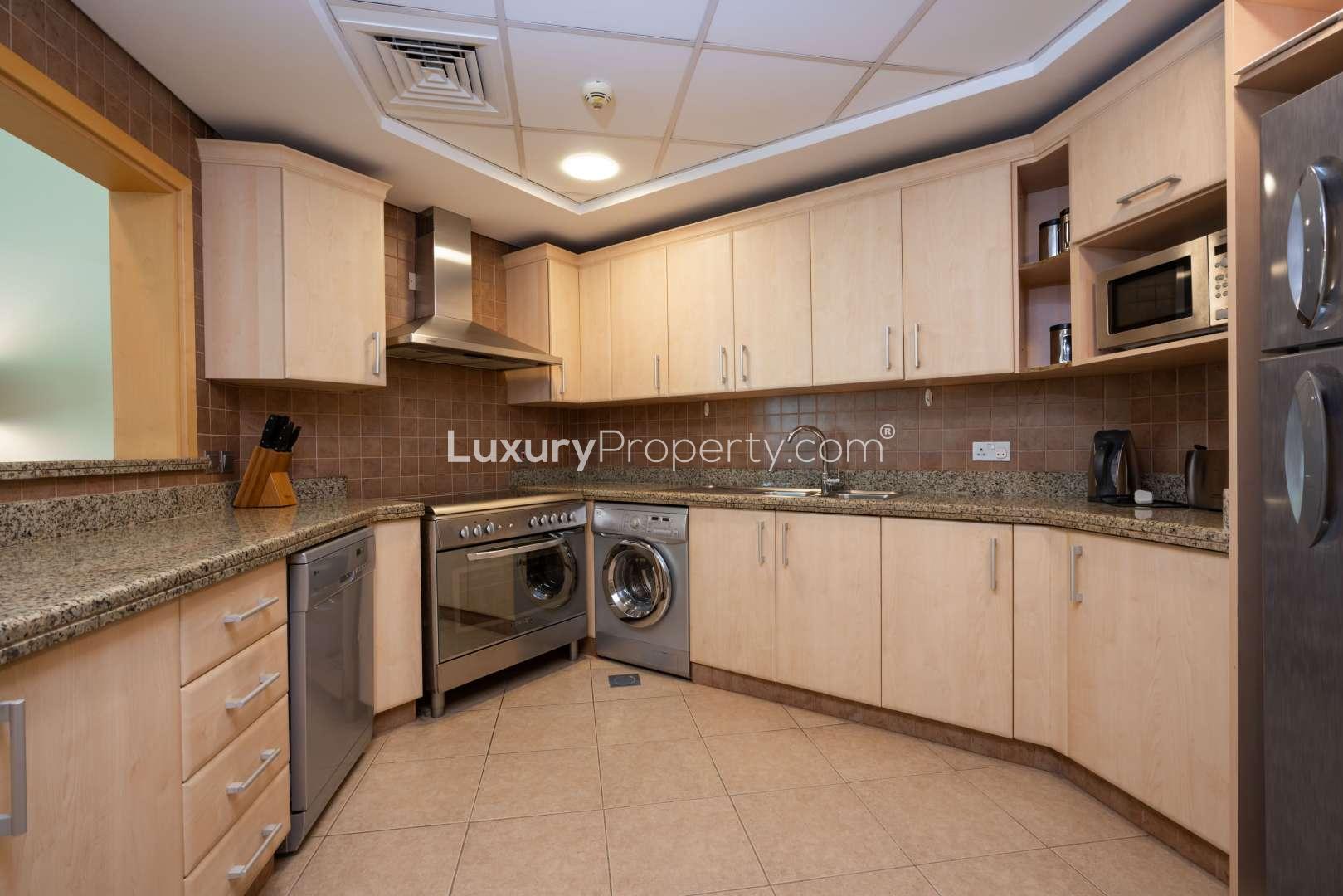 Modern kitchen in Shoreline Residences apartment, Palm Jumeirah, featuring granite countertops and appliances