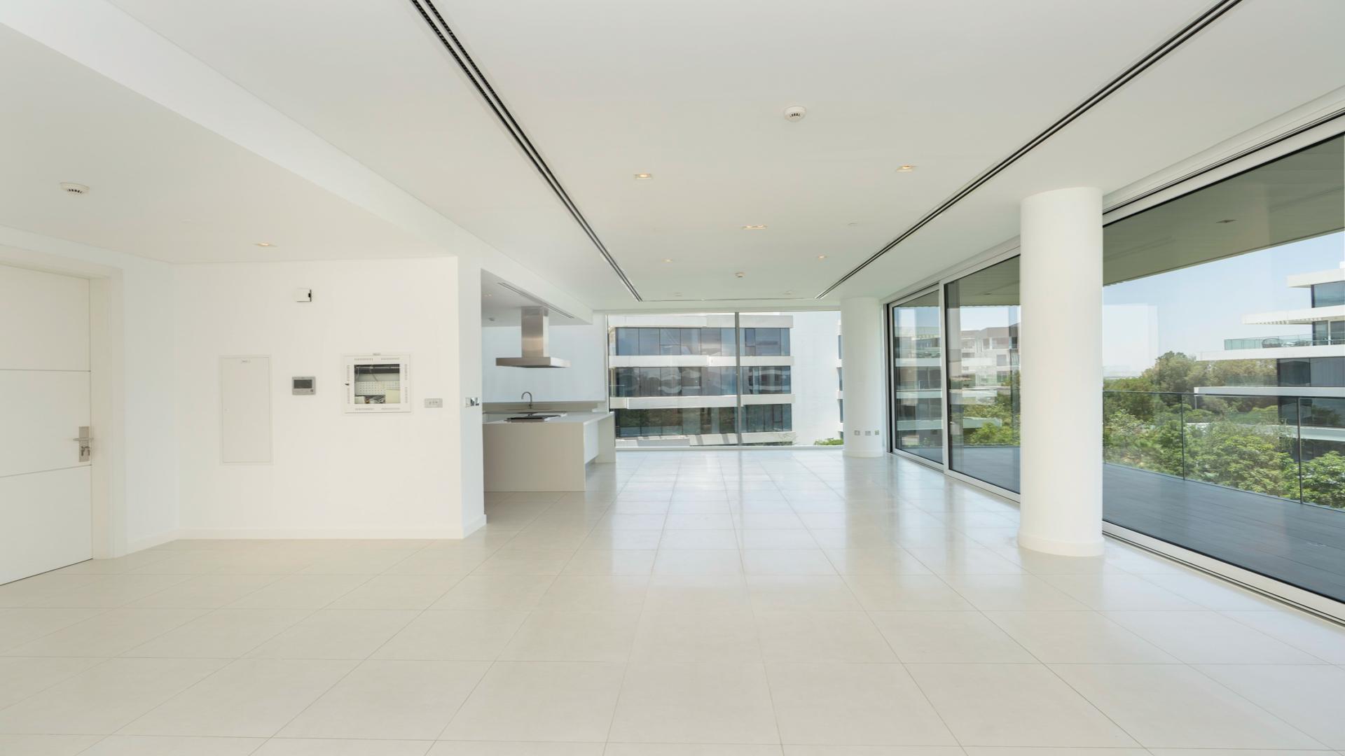 "Spacious living area with pool view in Ashjar apartment, Al Barari. Bright and modern design.",High-end 2-bed apartment interior with large windows and balcony in Ashjar, Al Barari