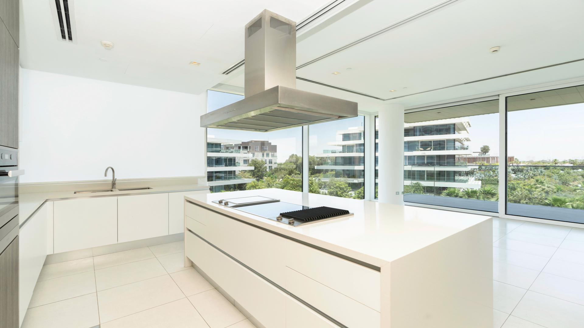 Balcony view from 2-bed apartment in Ashjar, Al Barari, overlooking lush greenery and pool