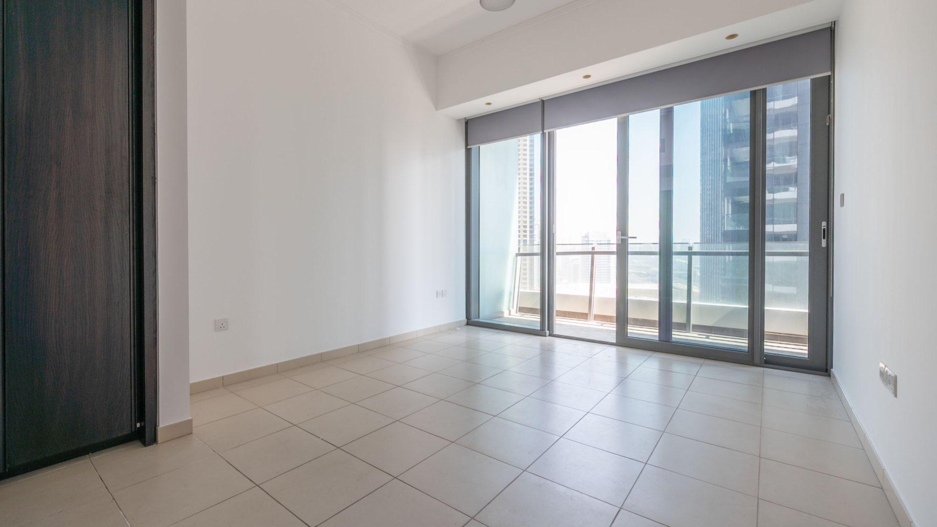Empty living room with large windows in Silverene Tower apartment, Dubai Marina