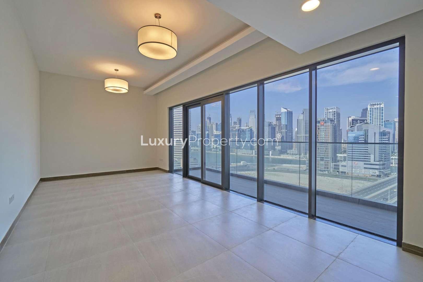 Empty living room in Business Bay apartment with modern lighting and tiled flooring