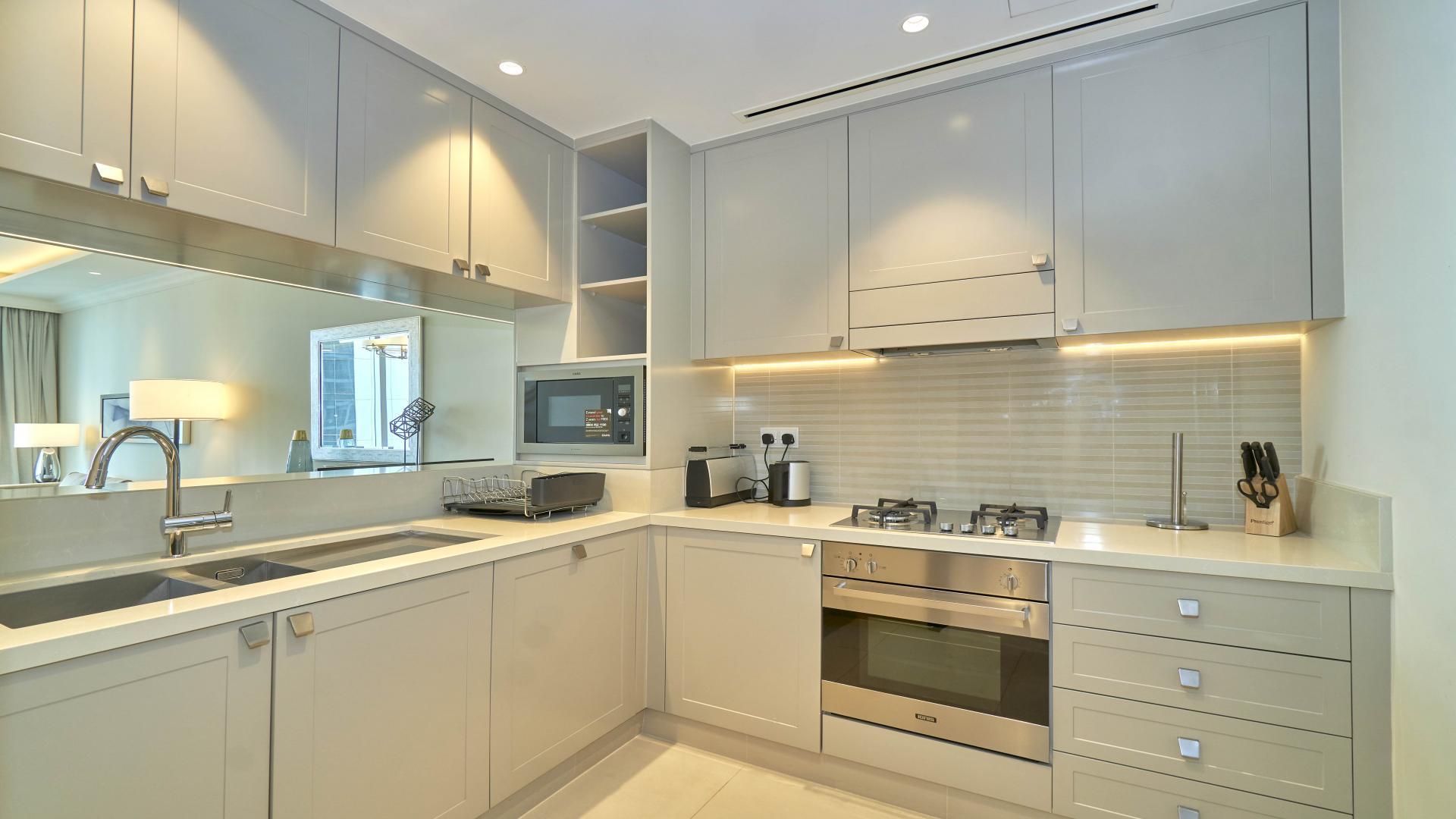 Modern kitchen in Downtown Dubai apartment, featuring sleek cabinetry and built-in appliances