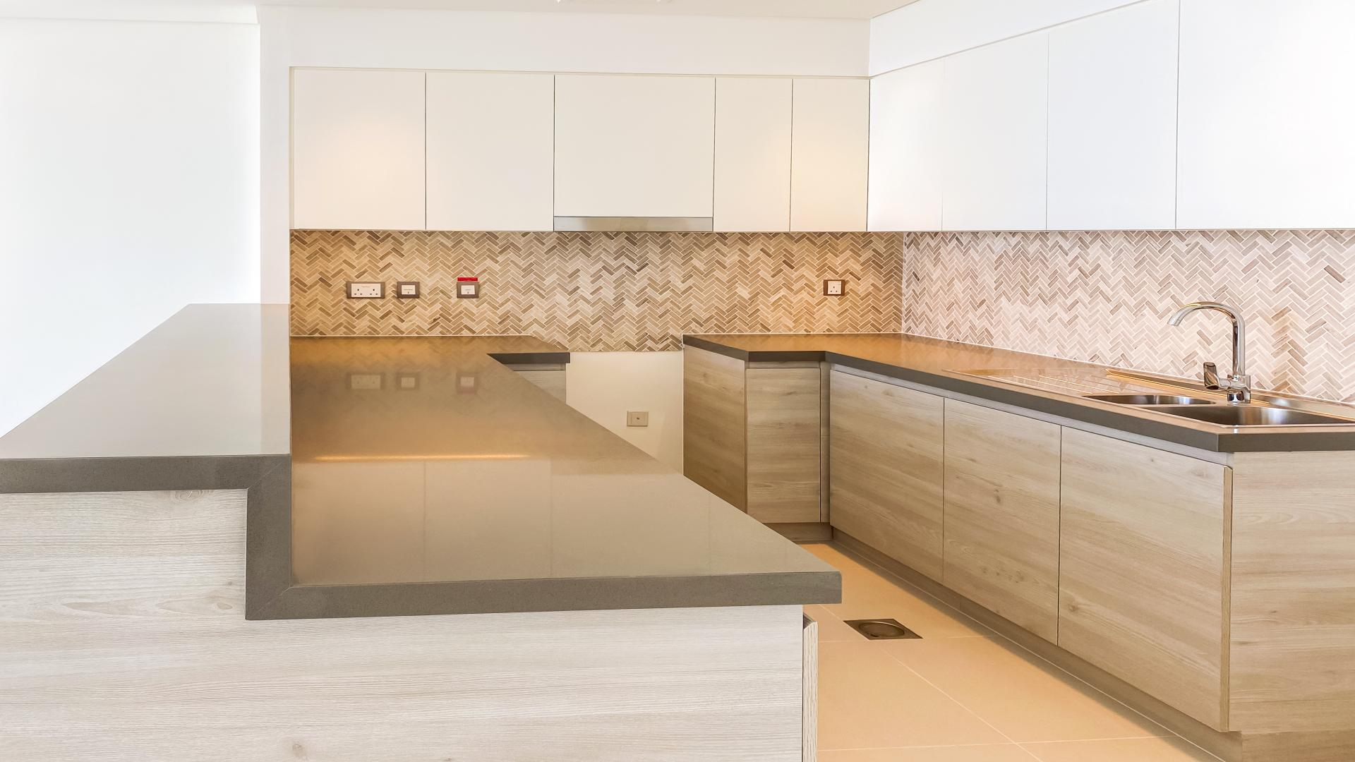 Modern kitchen in 2-bedroom apartment, The Cove 3, Dubai Creek Harbour, sleek countertops and cabinets