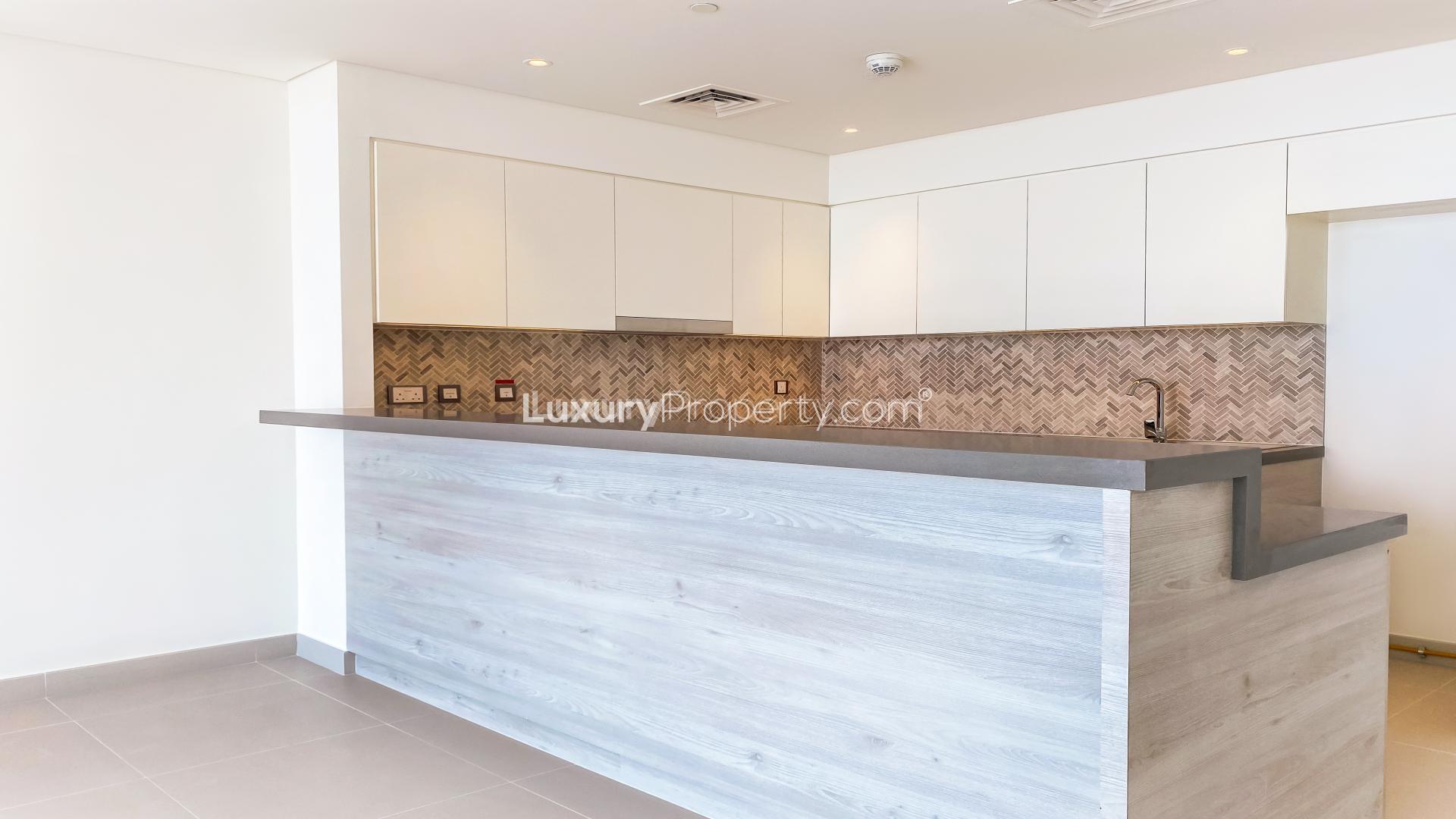 "Spacious living room with floor-to-ceiling windows and Burj Khalifa views in Dubai Creek Harbour.",Modern kitchen in luxurious 2-bedroom apartment, Dubai Creek Harbour, The Cove, Palm Jebel Ali