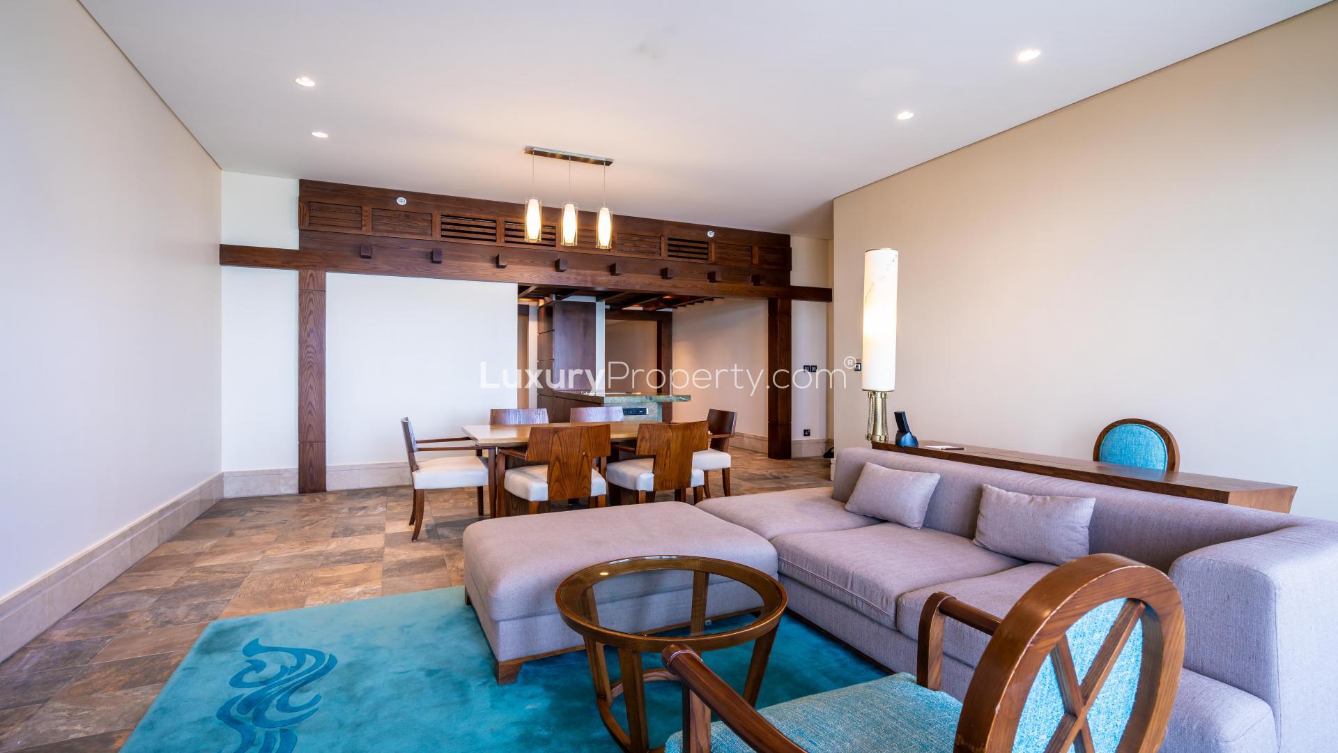 "Spacious living area with sea view in Palm Jumeirah serviced apartment for rent.",Modern living room in Palm Jumeirah serviced apartment, featuring elegant dining and seating area