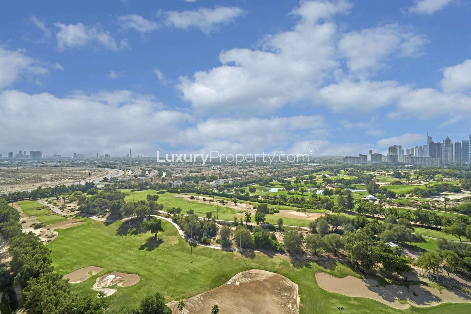 Spacious living room with large windows and golf course views in The Fairways apartment