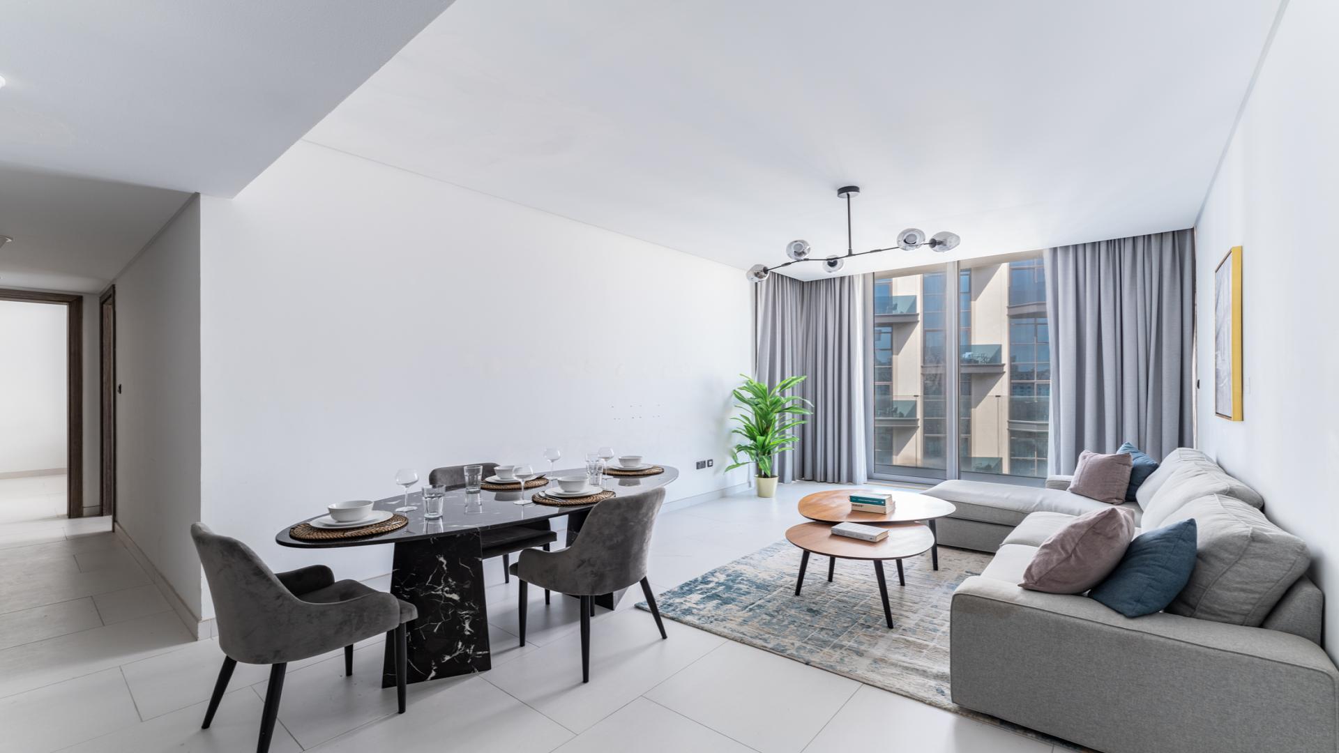 Modern kitchen in furnished 2-bedroom apartment, Soho Palm Jumeirah, with sleek white cabinetry